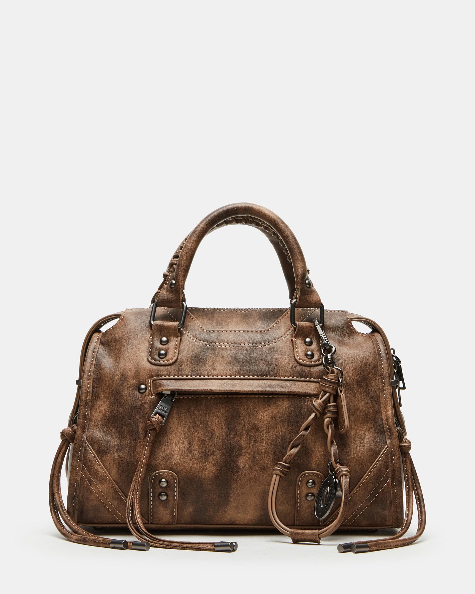 Distressed leather tote handbags displayed with accessories on a café table