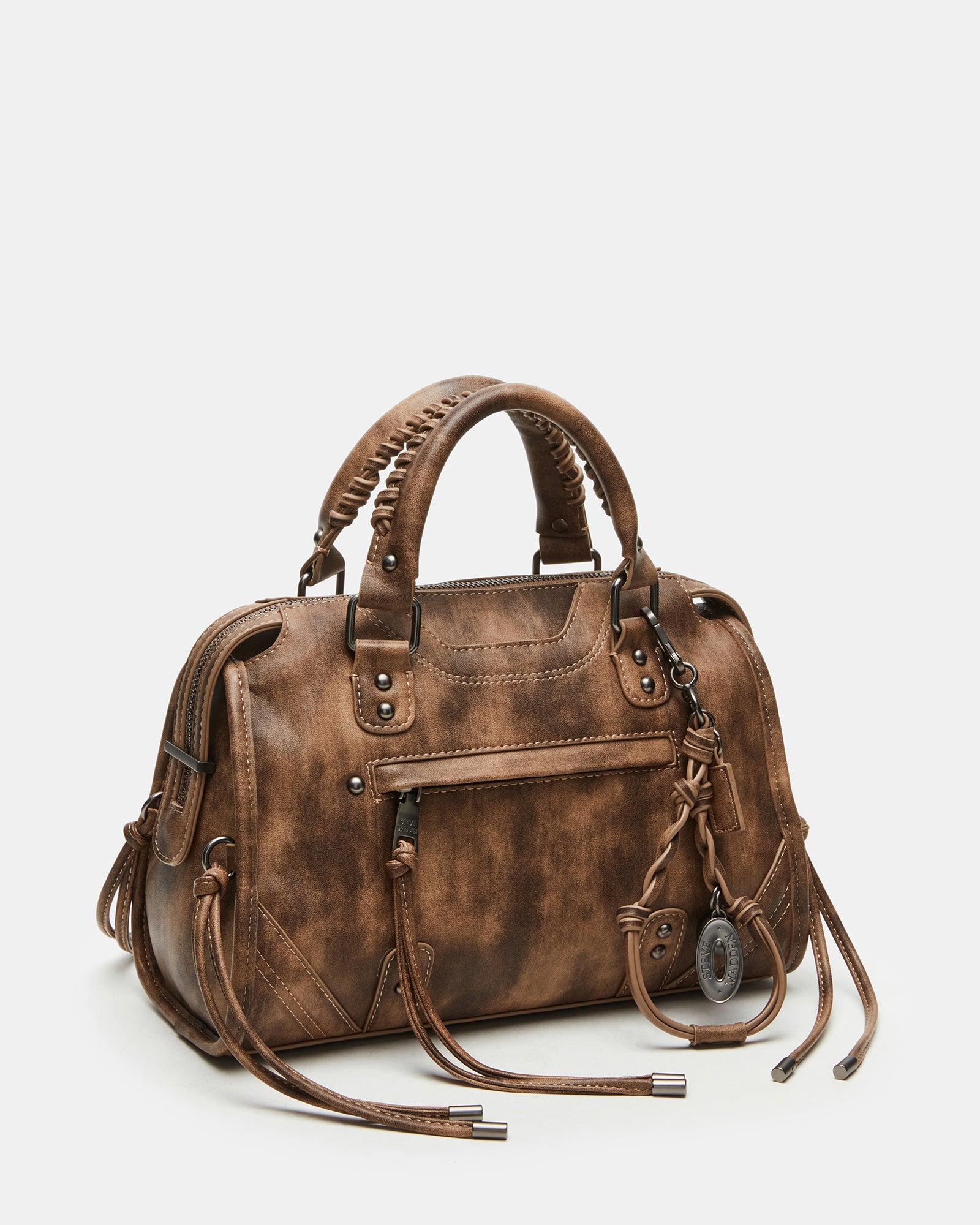 Distressed leather tote handbags displayed with accessories on a café table