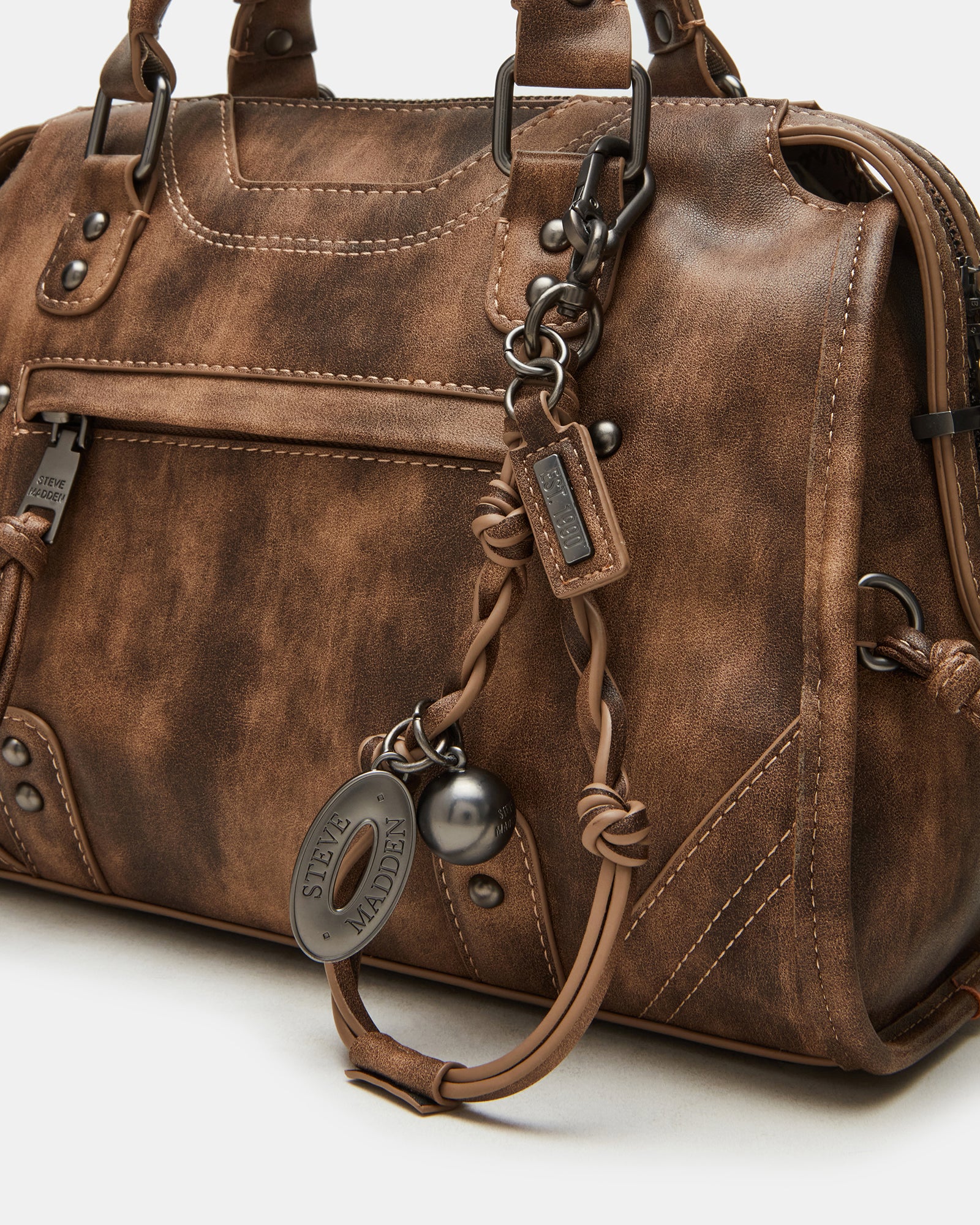 Close-up of distressed brown leather handbags showing texture and stud details