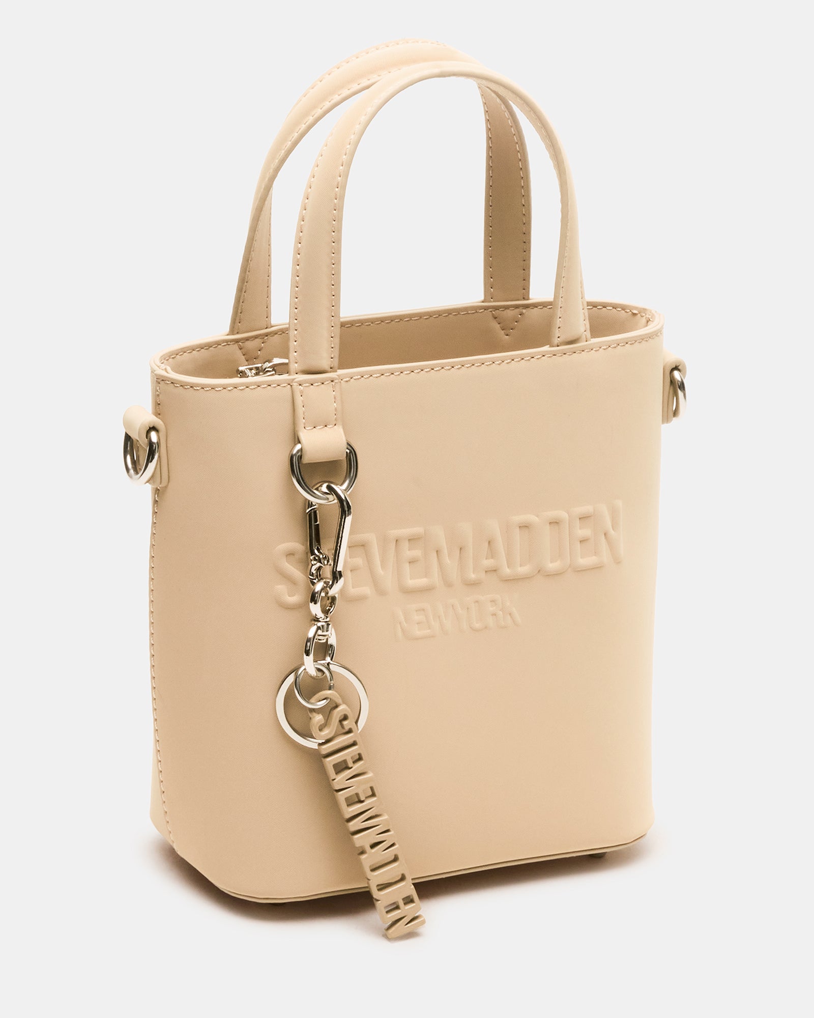 Front angle of khaki tote bag worn as shoulder bag on city street