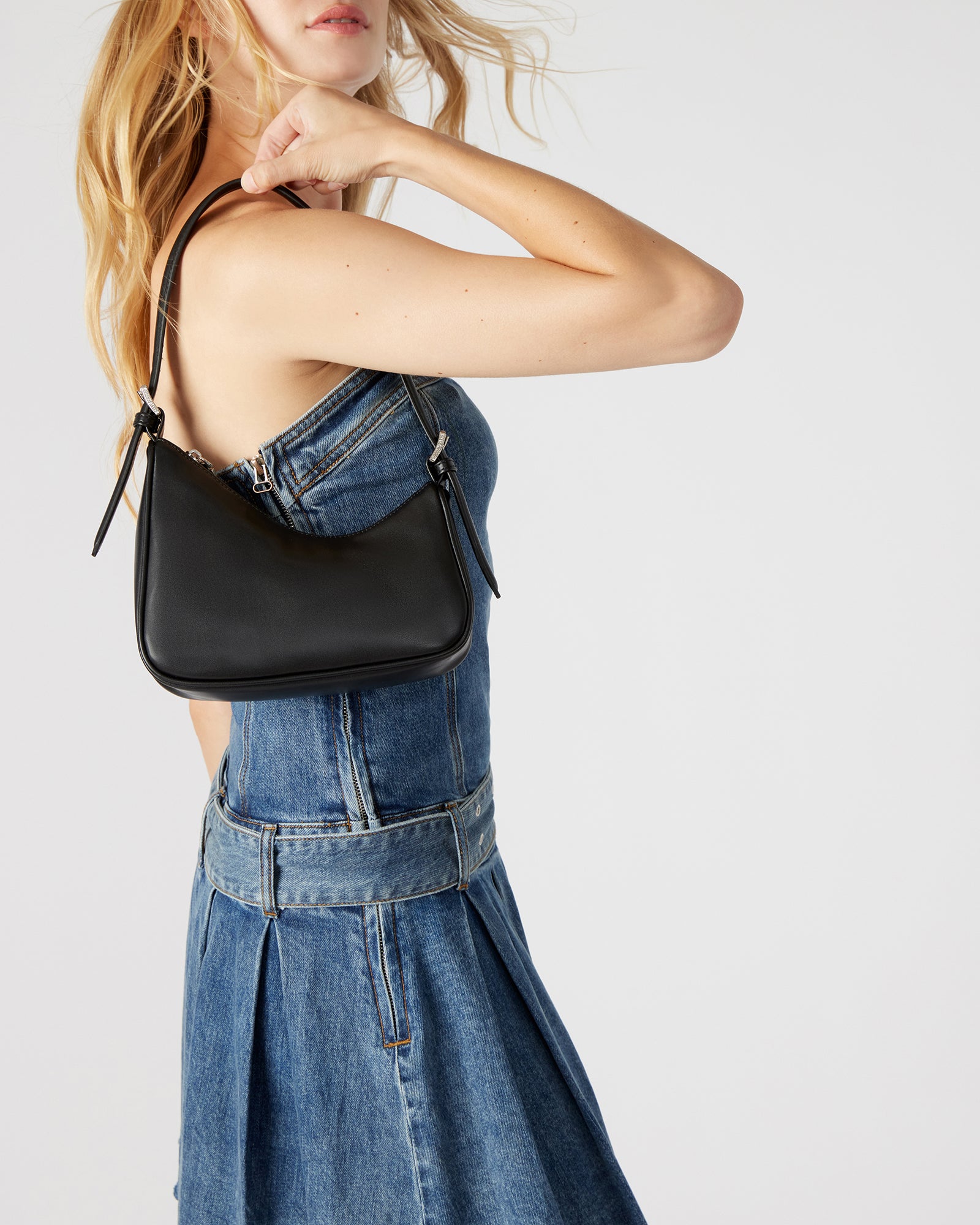 Interior of the black shoulder bag showing the zipper pocket and organization space
