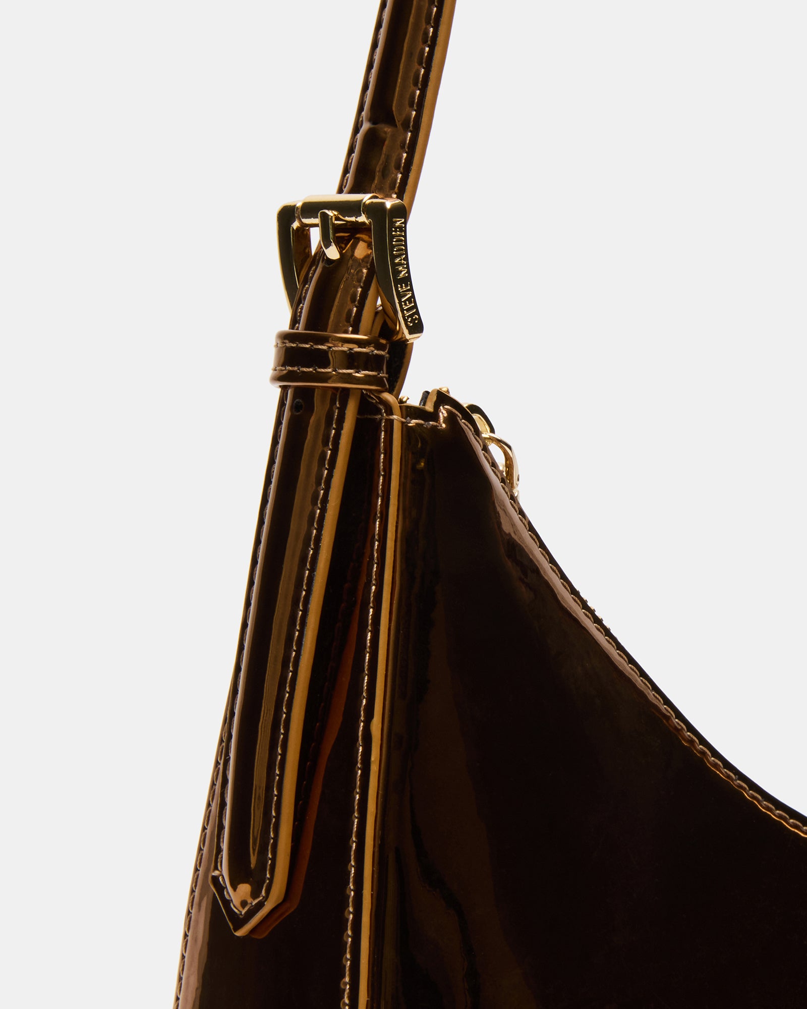 The Bronze Asymmetrical Shoulder Bag worn crossbody style against a city backdrop.