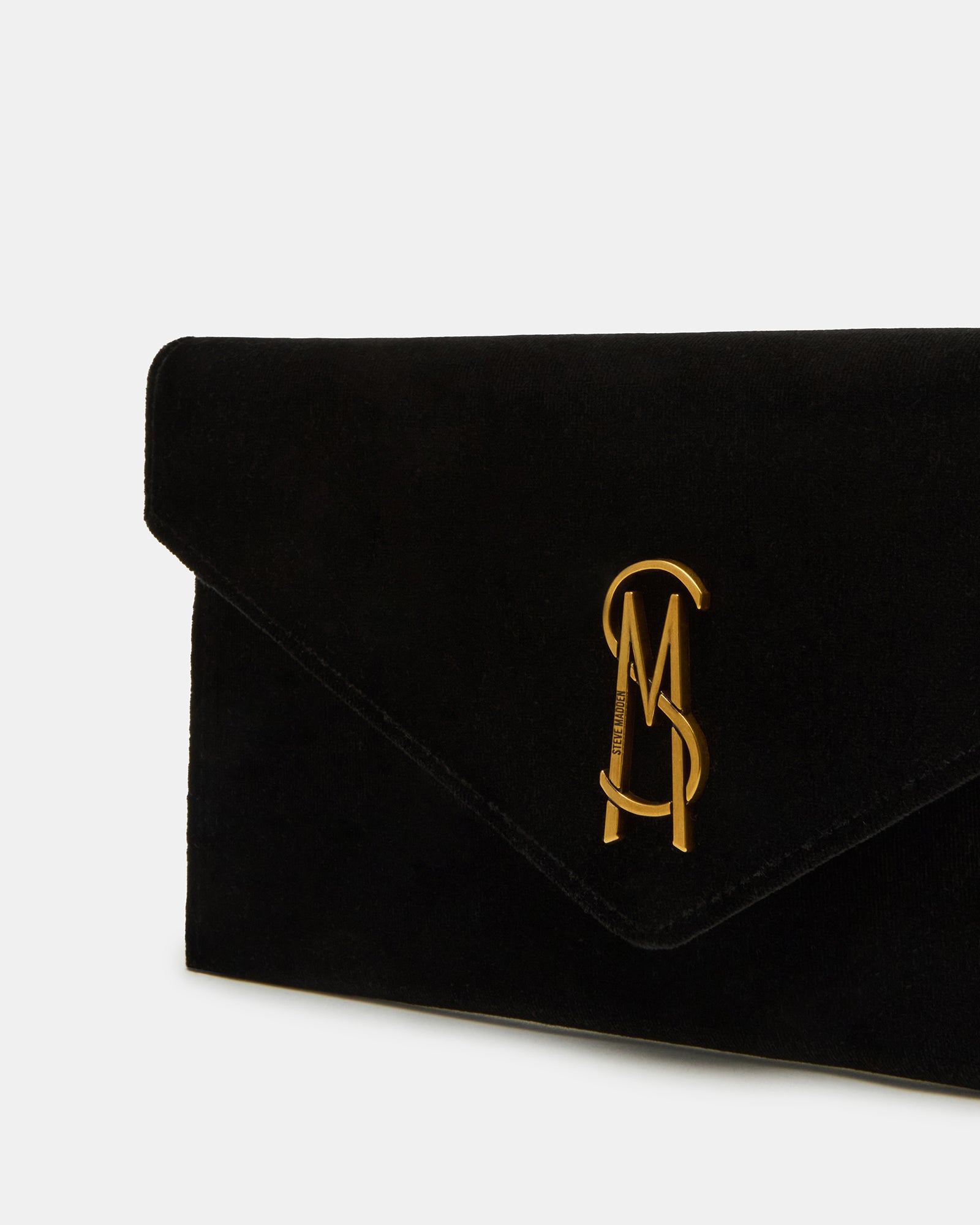 Model holding a stylish black envelope clutch bag at a party