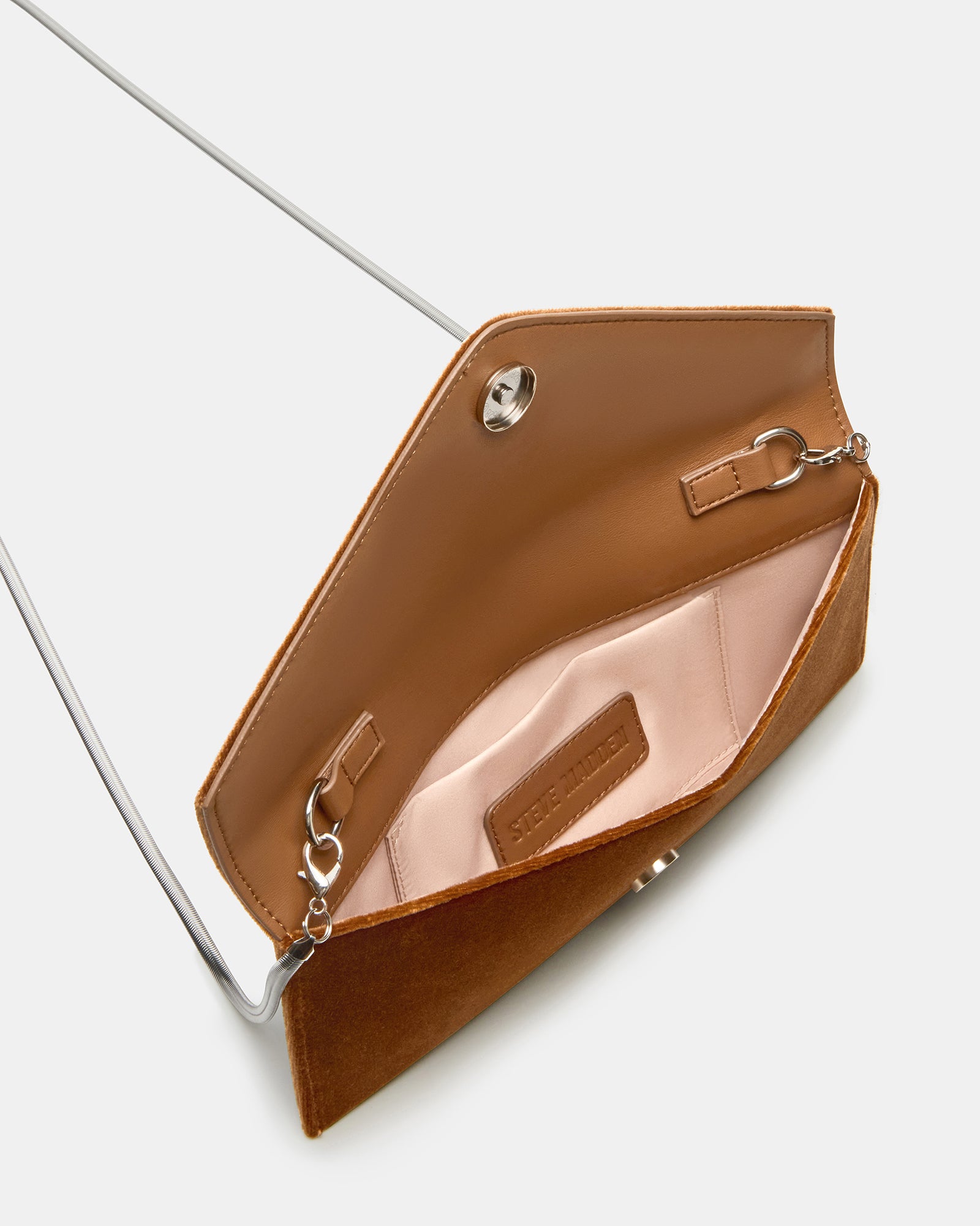 Side profile highlighting slim dimensions and chain strap on rust fabric bag.
