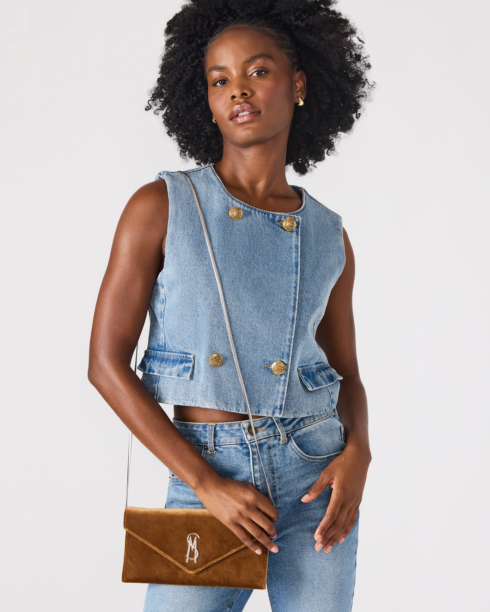 Side profile highlighting slim dimensions and chain strap on rust fabric bag.