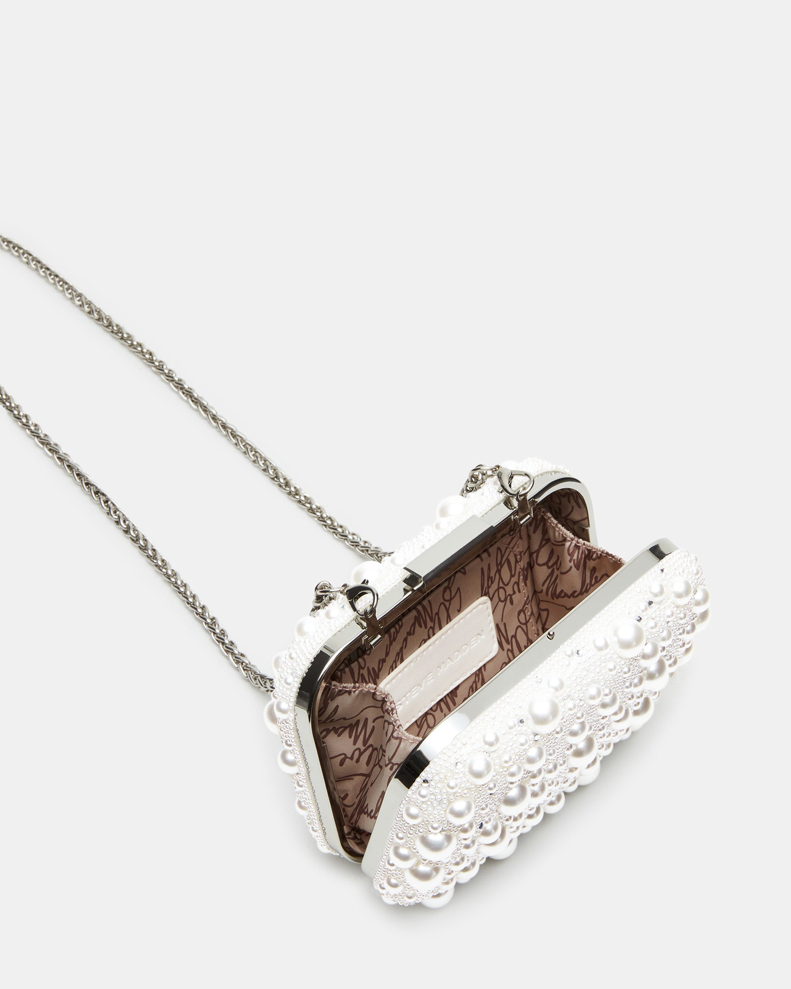 Side angle of the ivory pearl crossbody bag on a stylish outfit