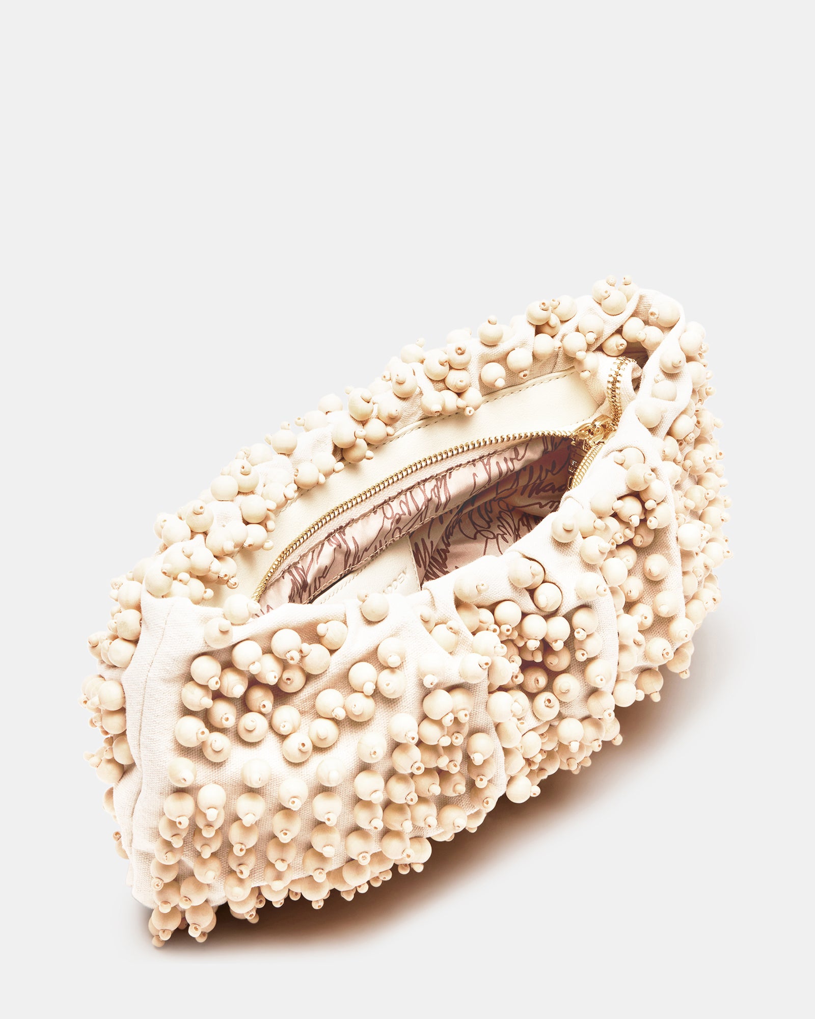 Tiki wristlet bag displayed on a sandy beach, ideal for summer.