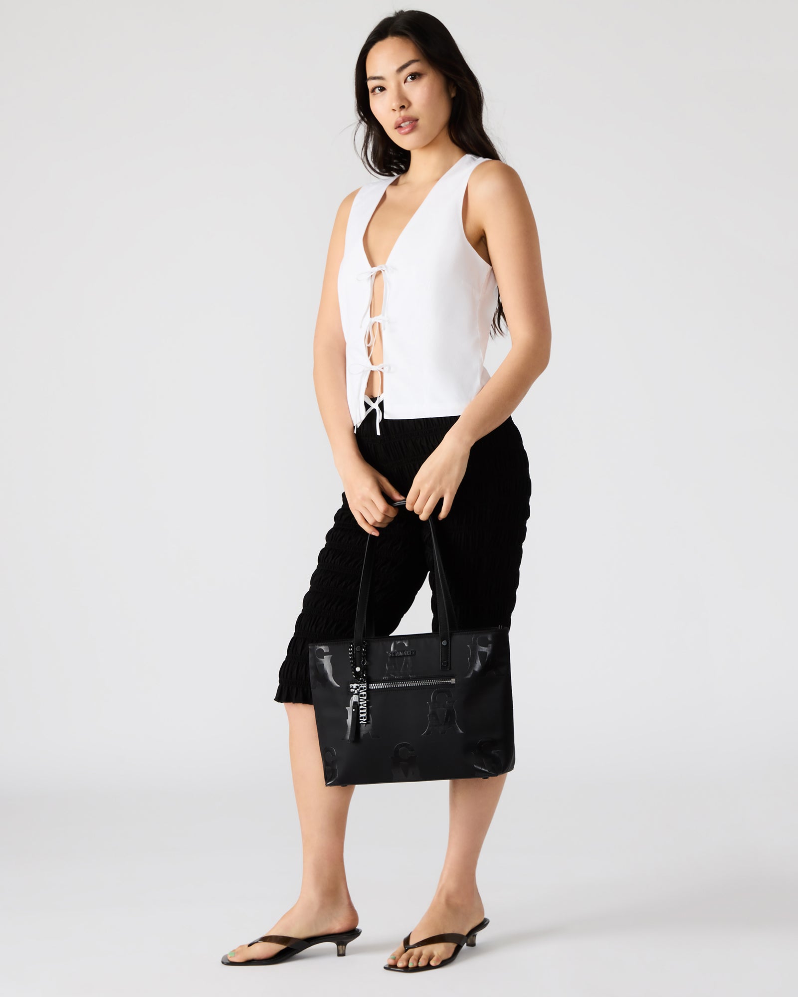Close-up of attachable charm on fashion tote bag, highlighting accessory detail