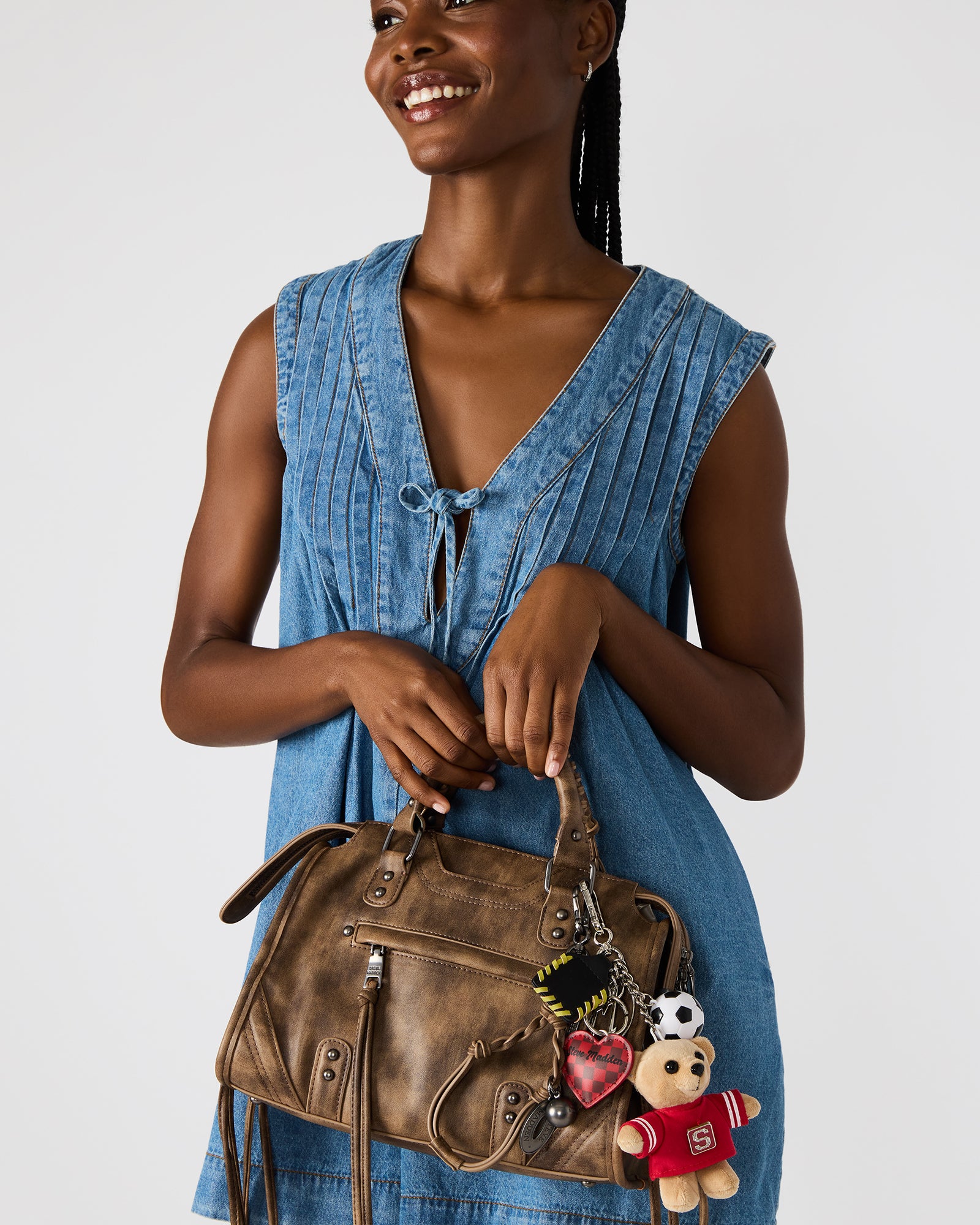 Attachable bag charm with dog clip attachment on designer bag