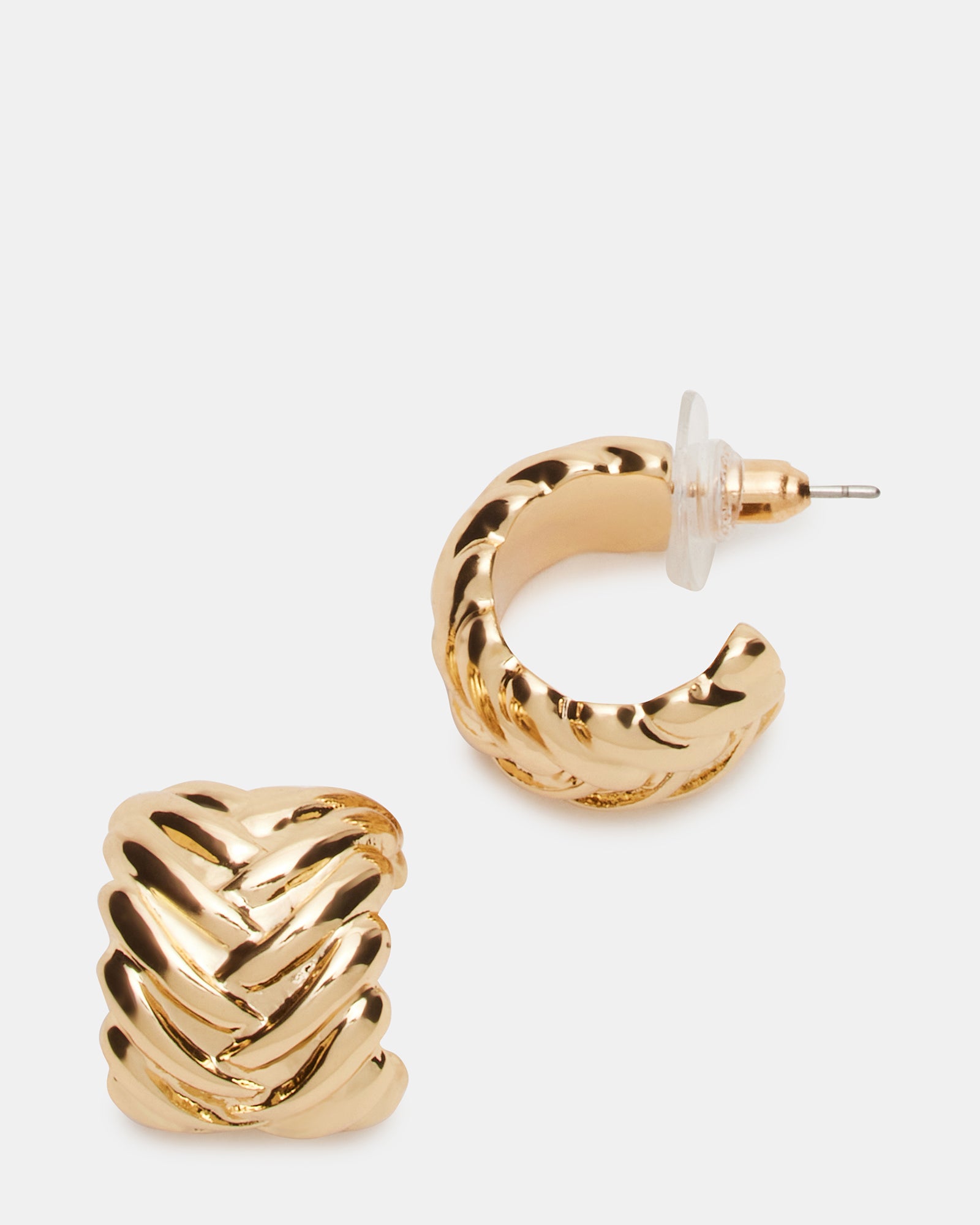 Woven gold huggie earrings displayed on a velvet tray, showcasing intricate texture.