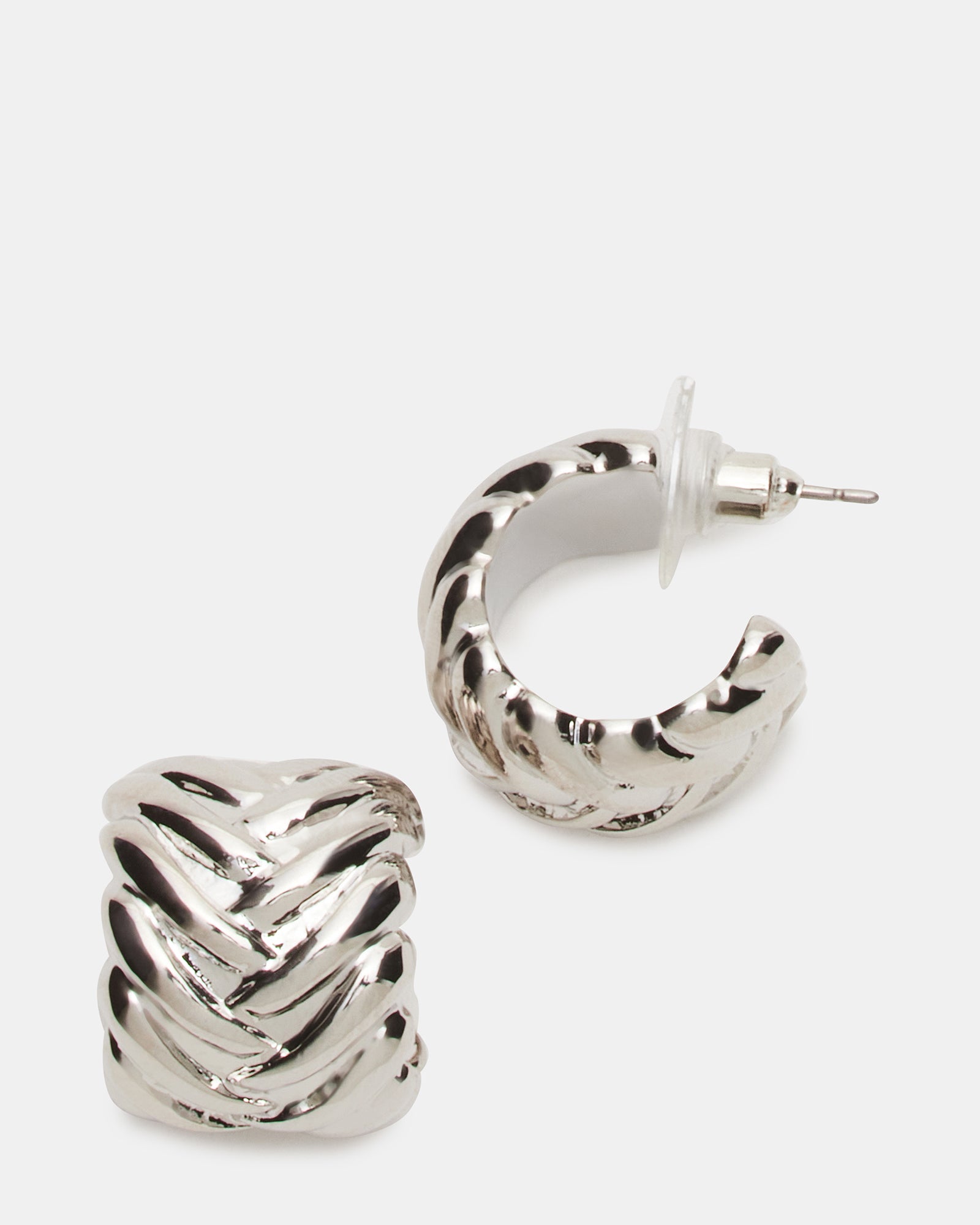 Woven silver huggie earrings modeled on a woman’s ear