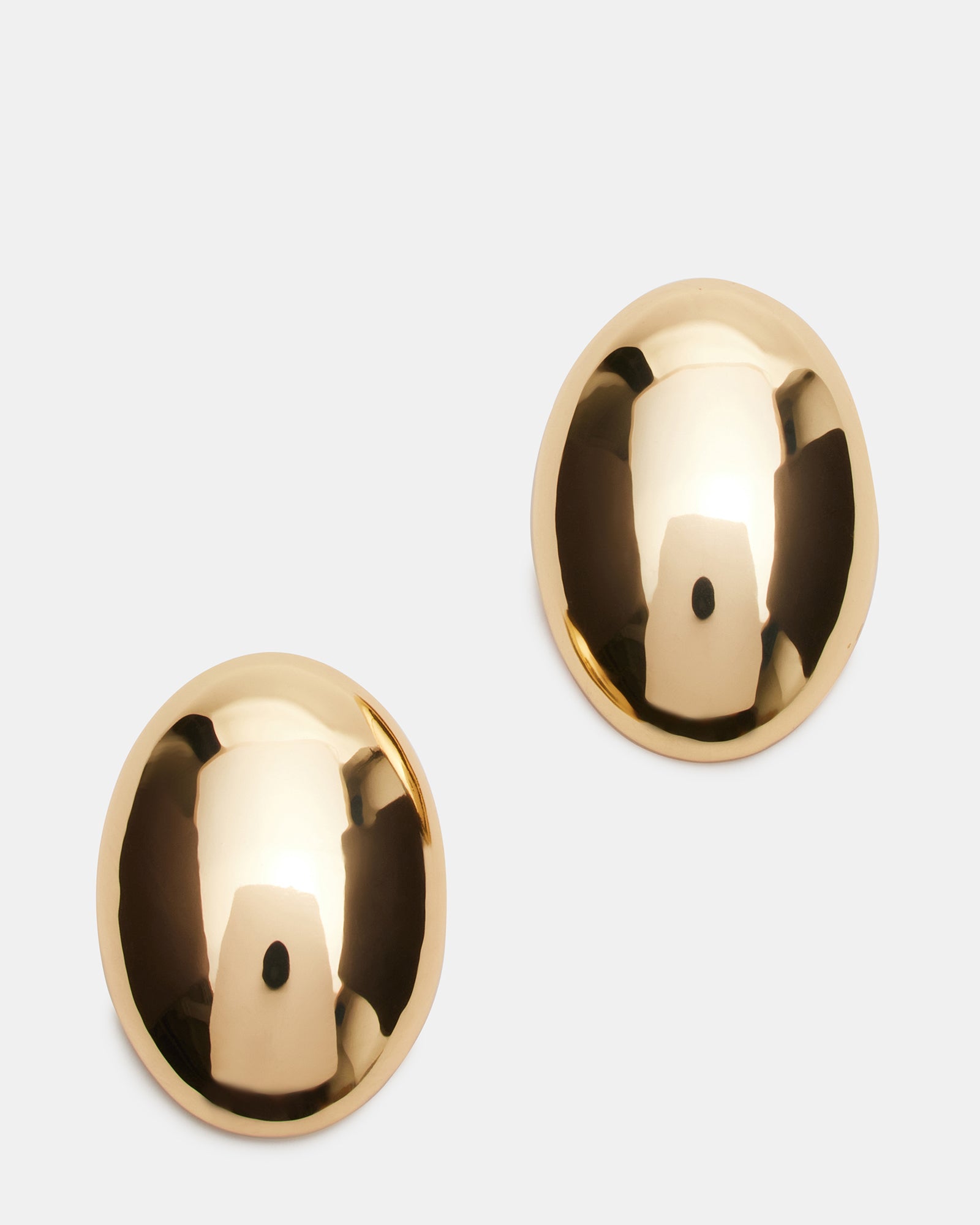 Gold oval stud earrings displayed on velvet jewelry tray in natural light