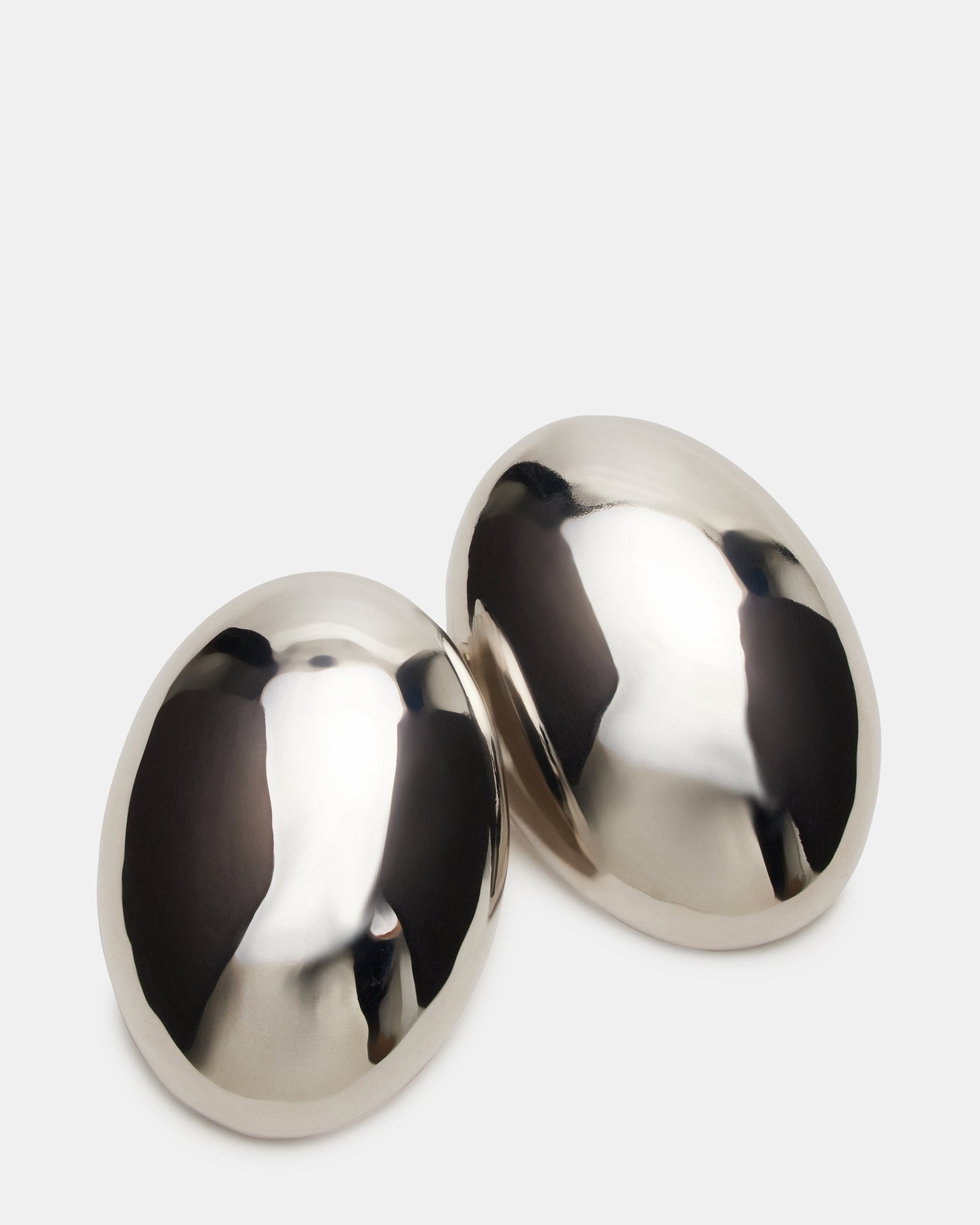 Model wearing oval silver stud earrings, enhancing a chic outfit.