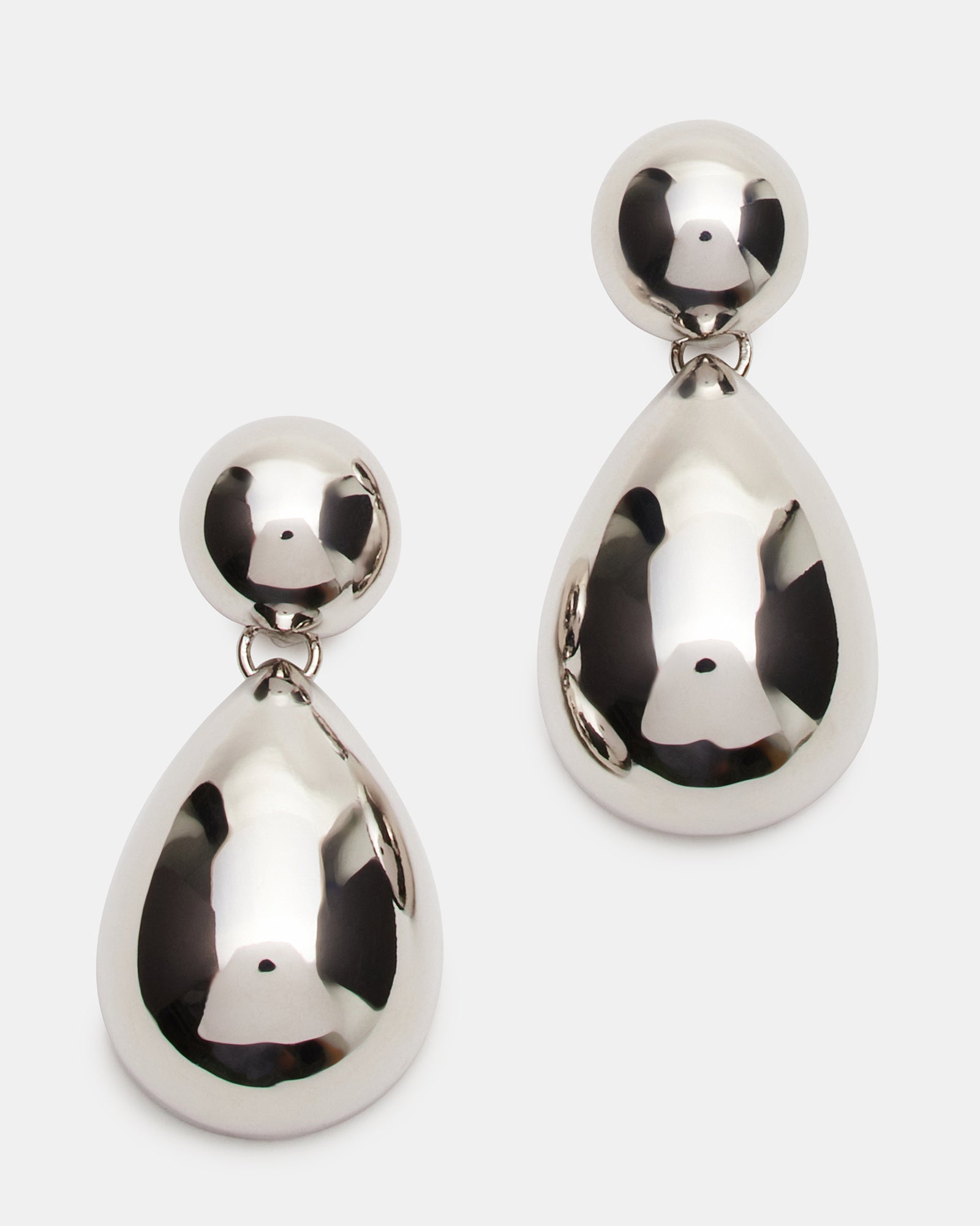 Close-up of silver double teardrop earrings showcasing intricate design