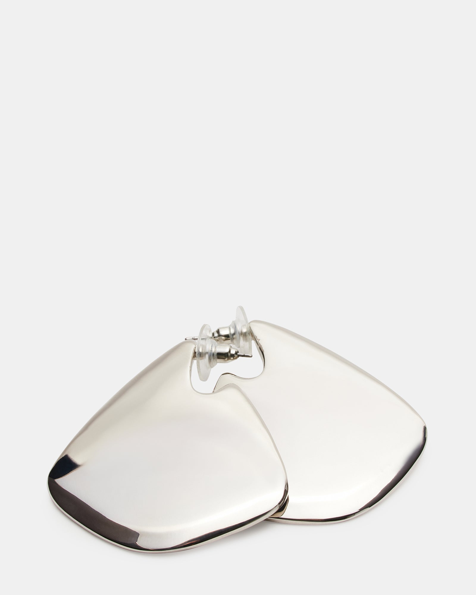Stylist’s flat lay featuring geometric earrings with leather accessories