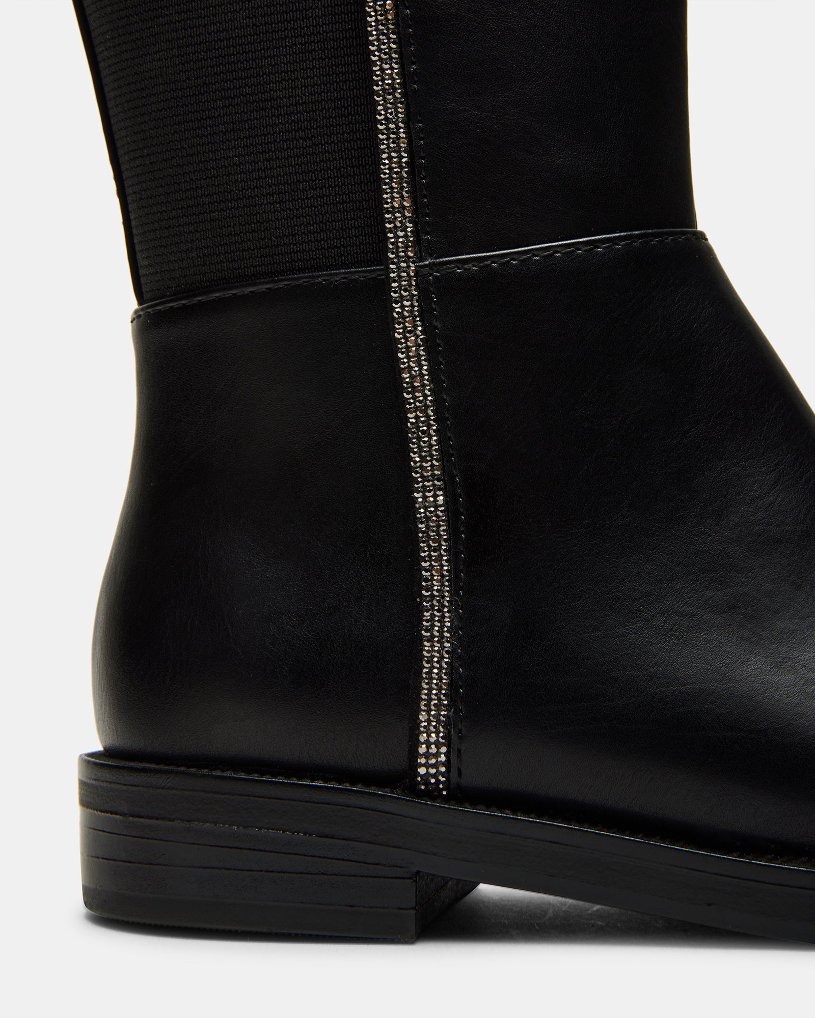 Close-up of the textured synthetic sole of vegan leather boots for kids