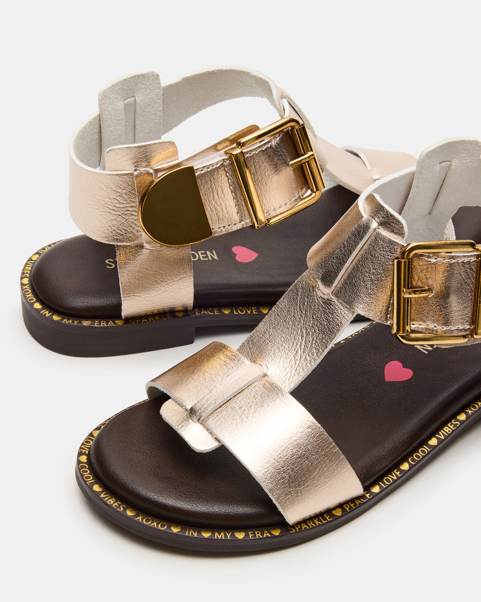 Top view of white and gold flat sandals for children arranged with play gear