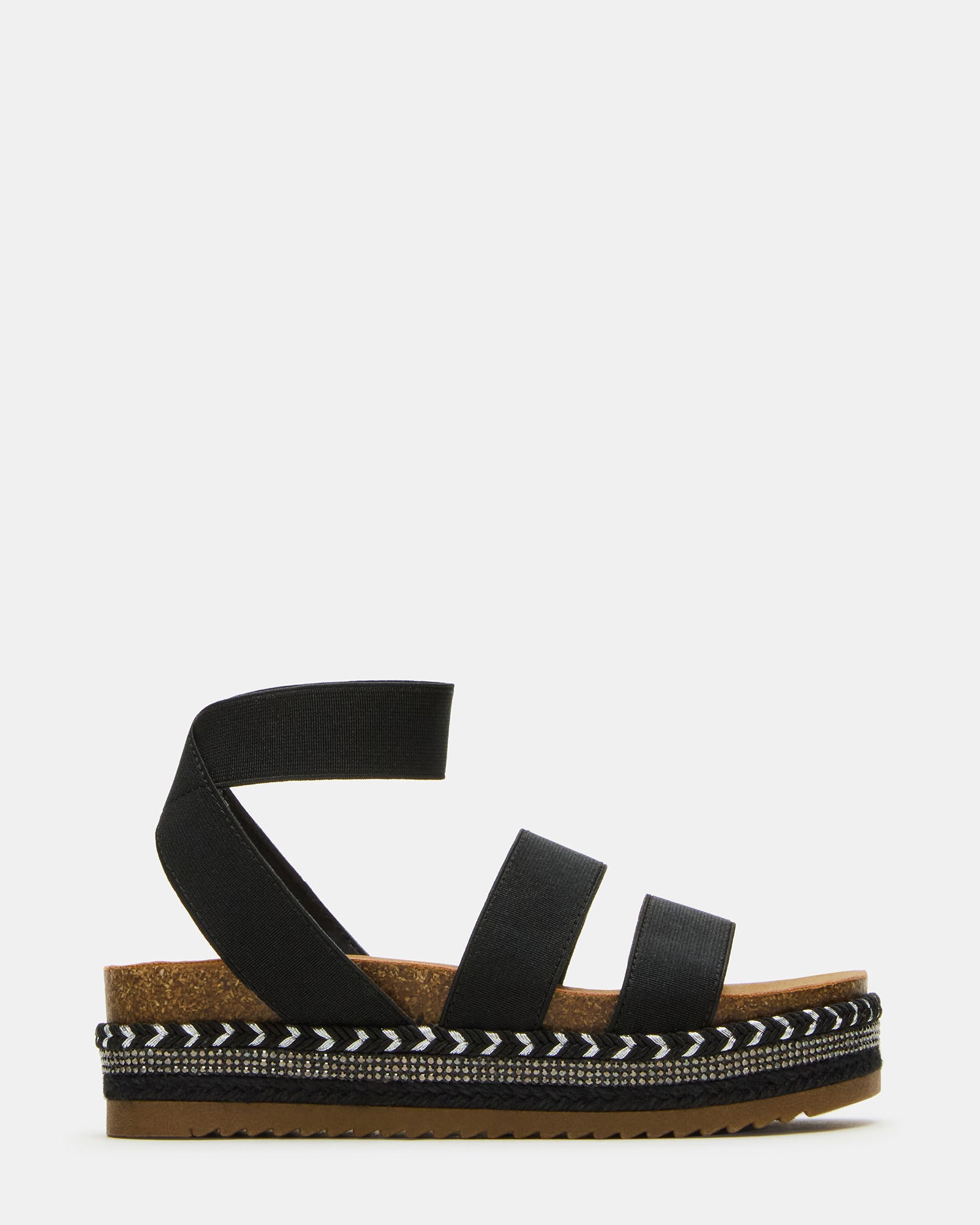 Front view of black platform sandals for kids on sidewalk near playground