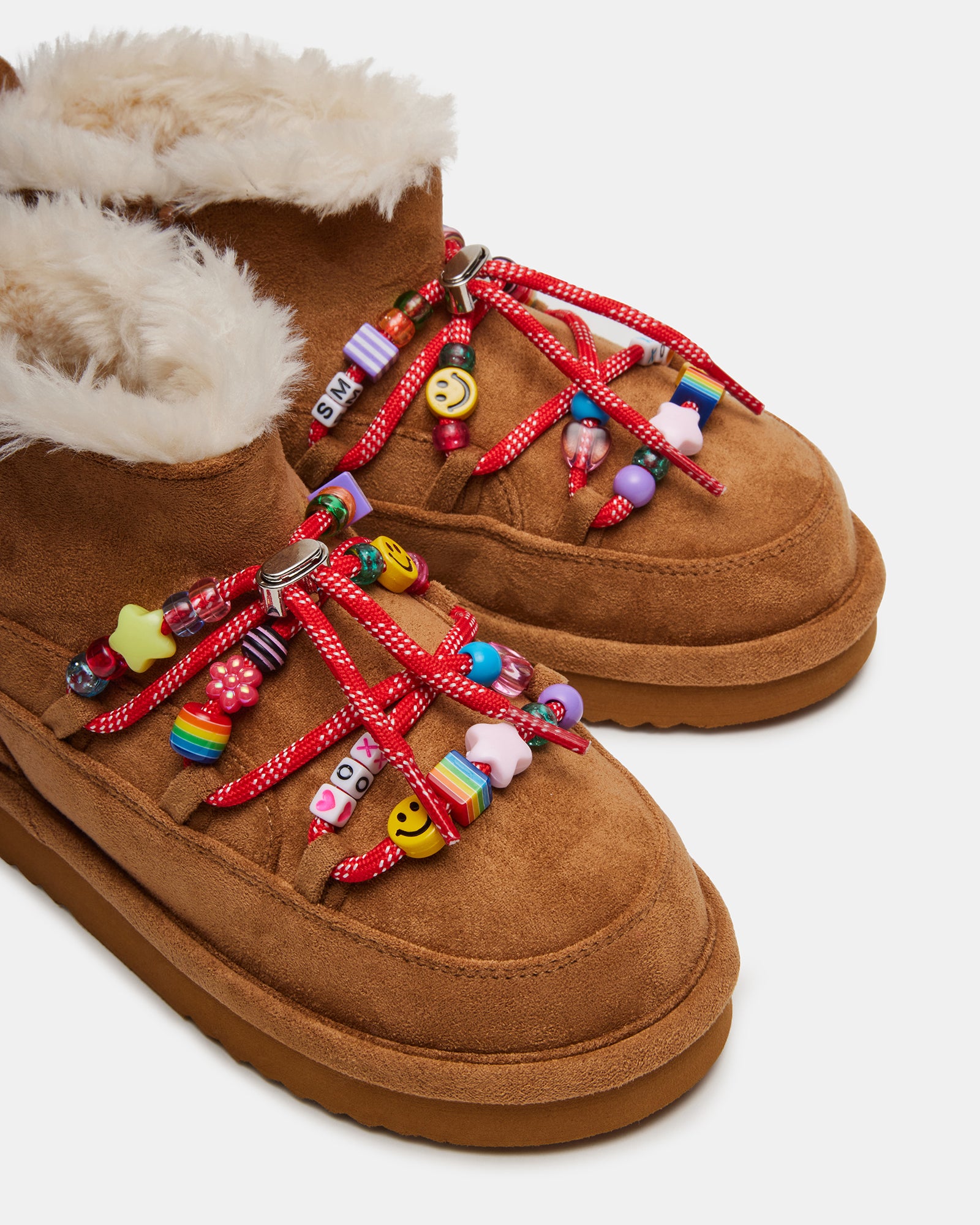 Close-up of black ankle boots bead detail against snowy backdrop