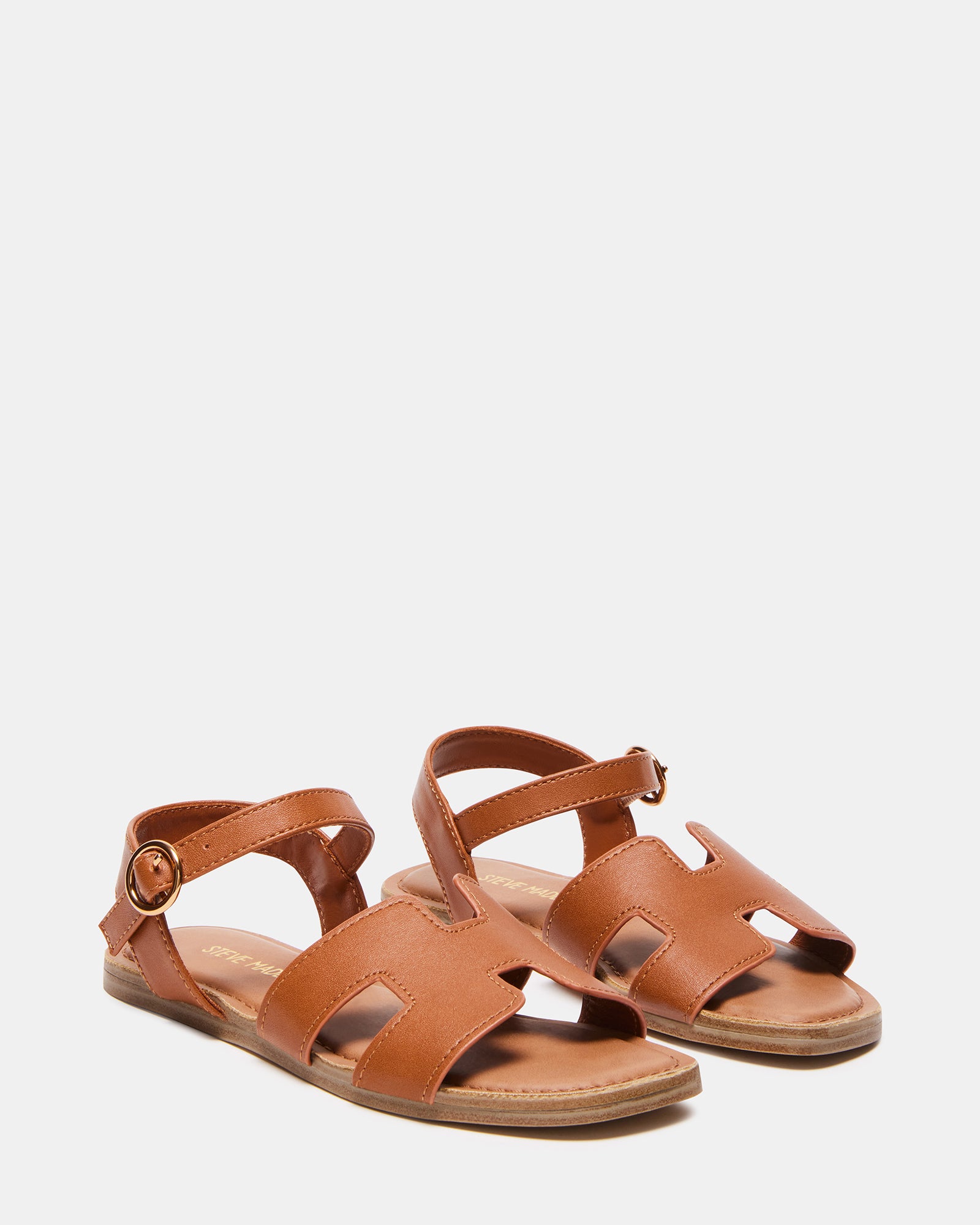 Child wearing cognac sandals at the beach