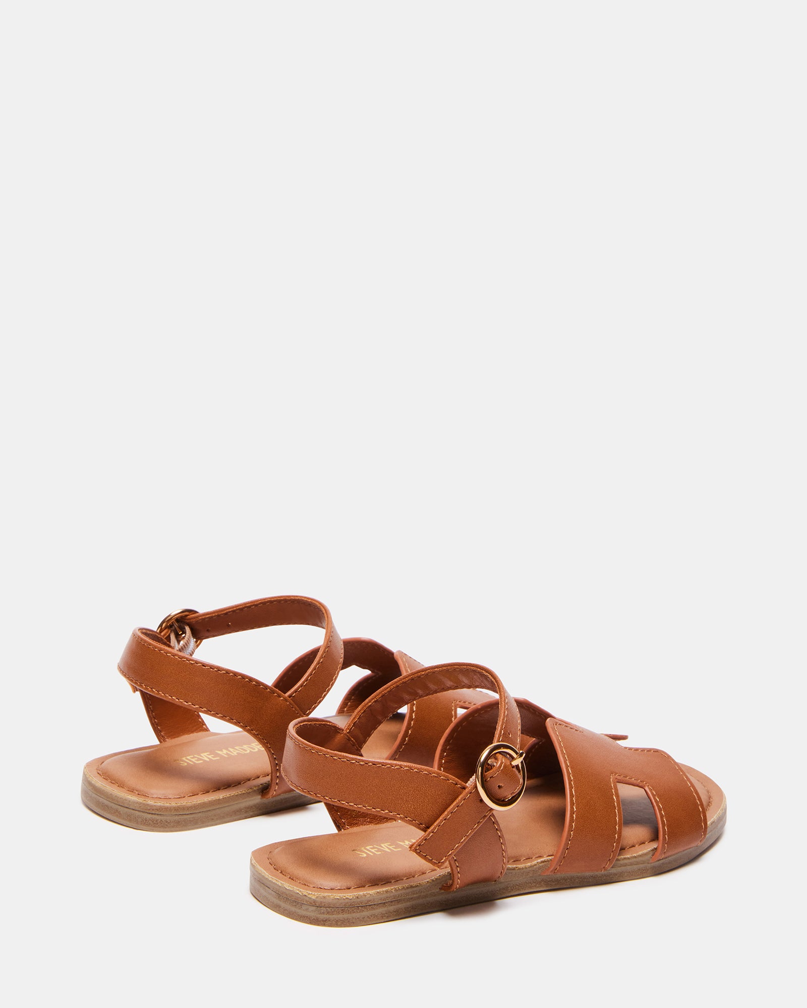 Child wearing cognac sandals at the beach