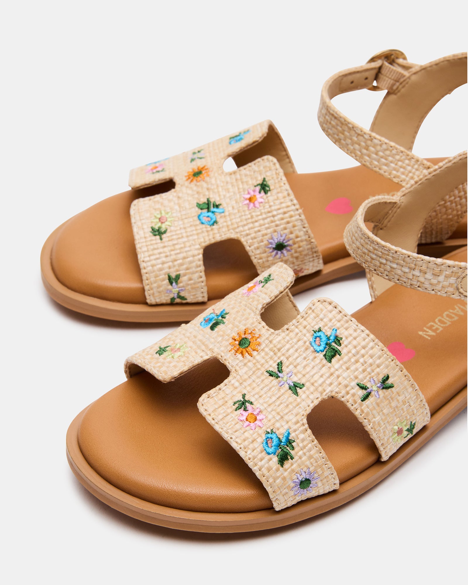 Child wearing floral Doc Marten-style sandals on grass