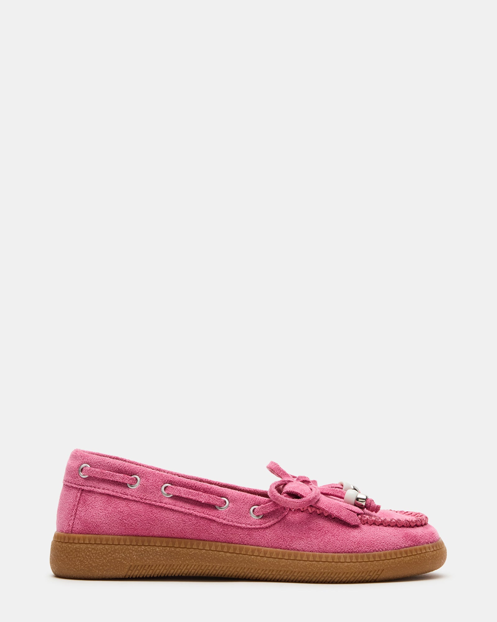 Side view of pink kids' boat shoes on wooden background