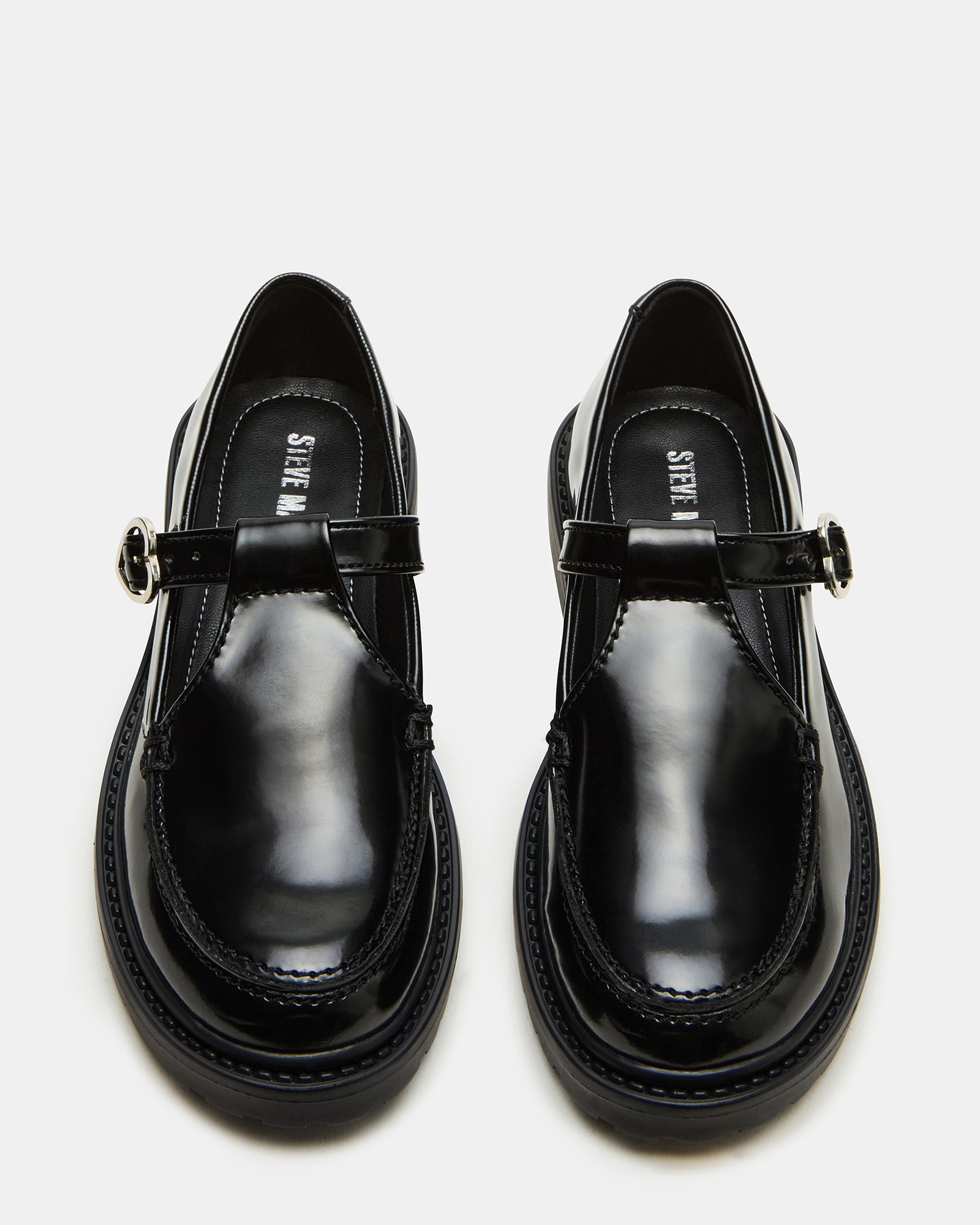 Toddler girl wearing black Mary Jane loafers at a park