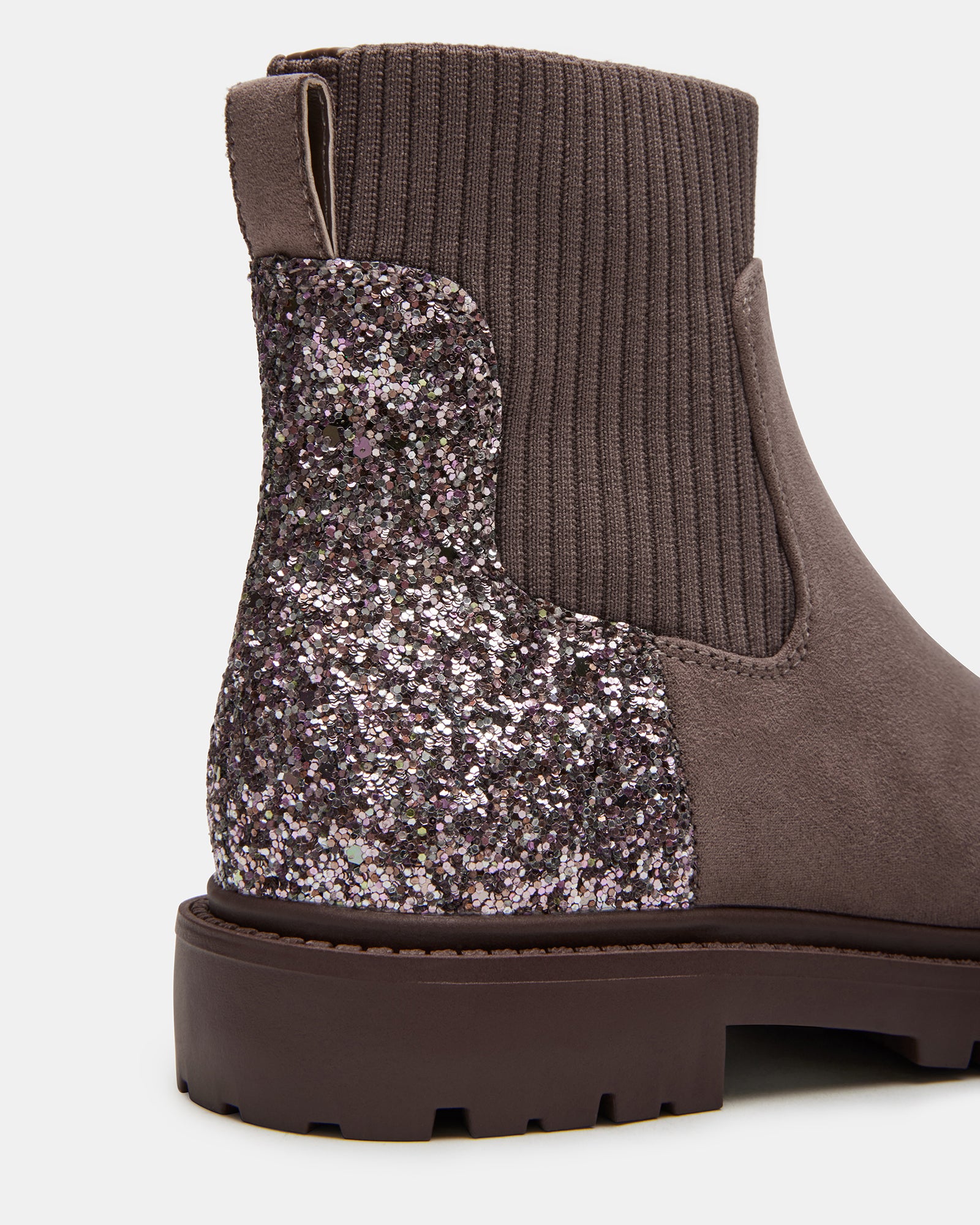 Child wearing taupe glitter boots outdoors in winter.