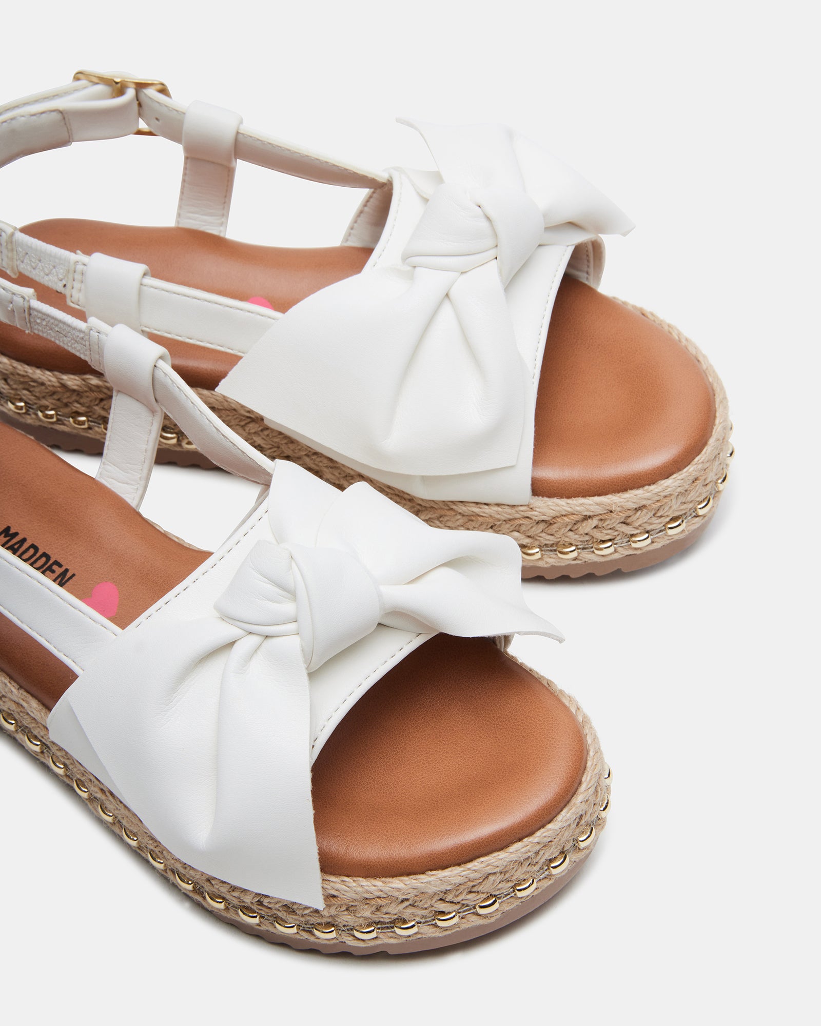 Front view of kids white sandals showcasing the bow accent and natural materials