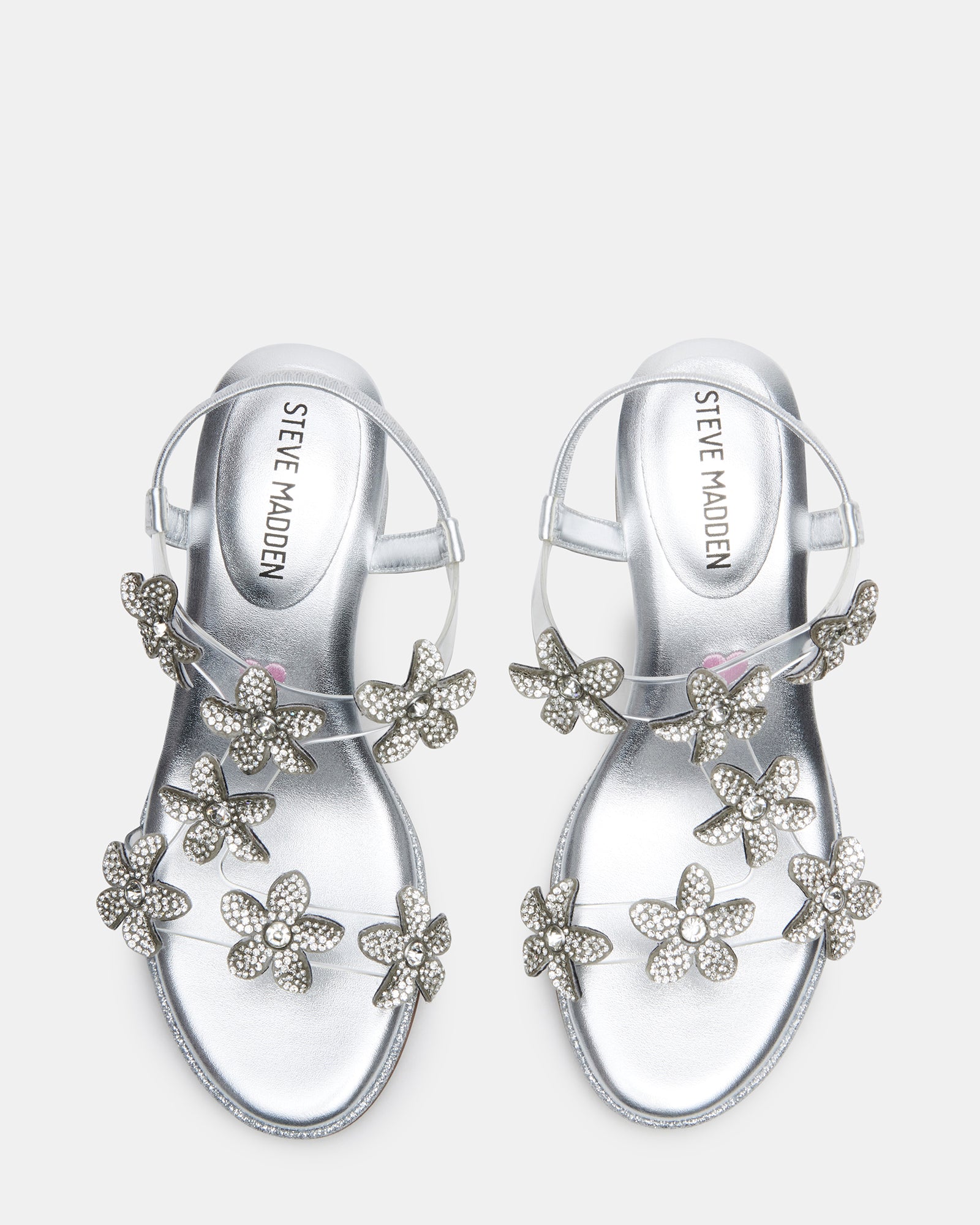 Close-up of silver kid shoes with rhinestone flowers on strap