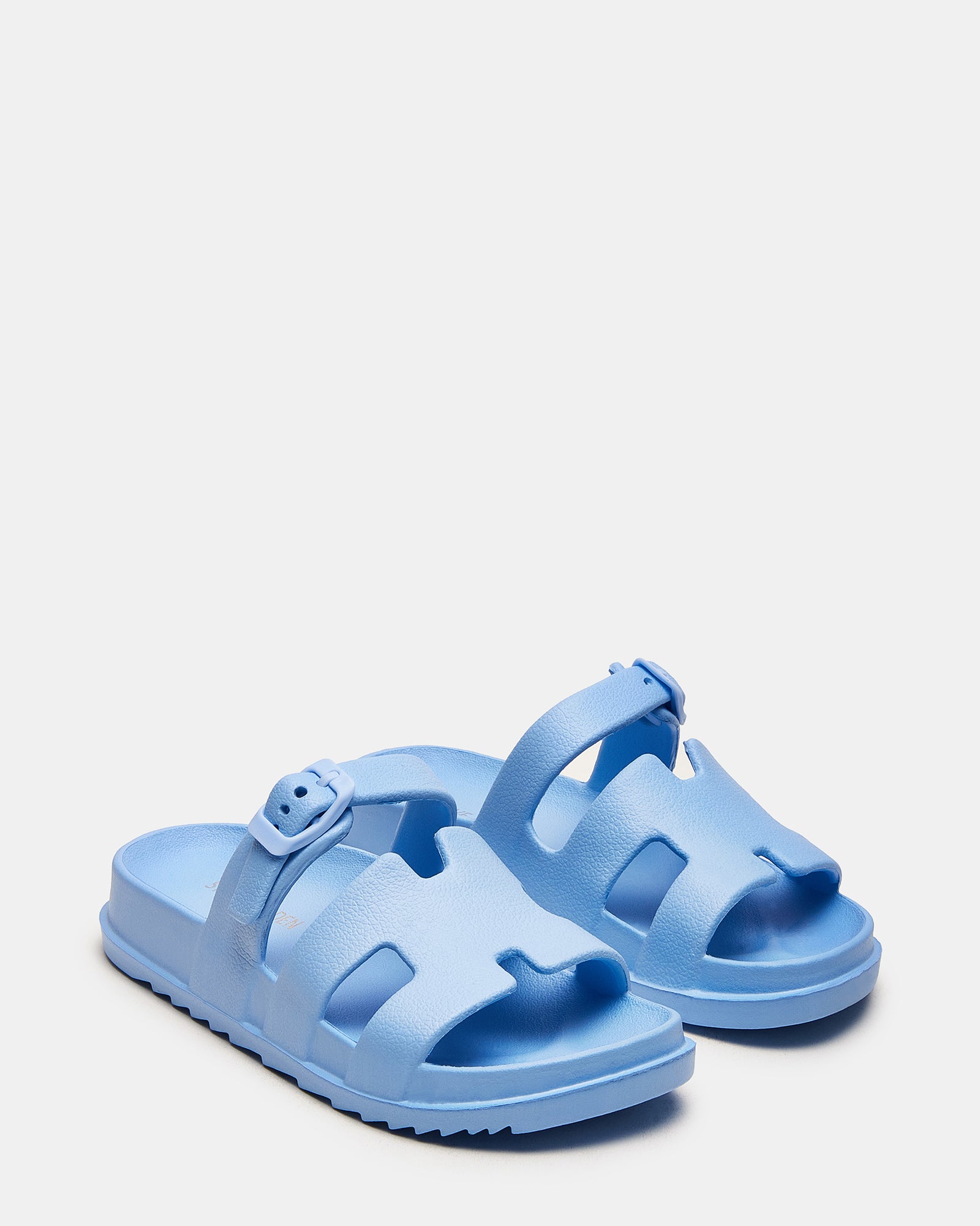 Side view of blue slide sandals highlighting 1.5 inch heel and textured sole