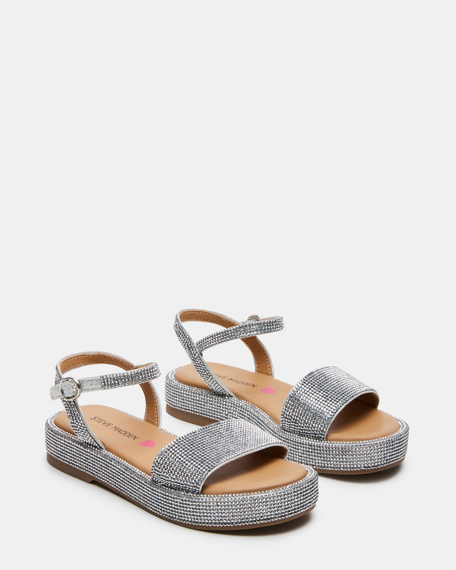 Child wearing silver platform sandals outdoors, ankle strap fastened