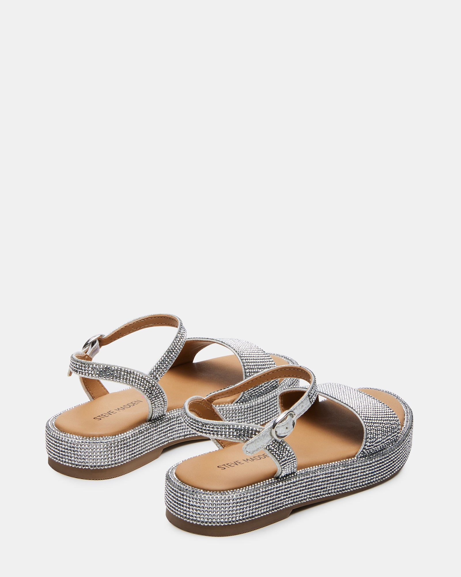 Child wearing silver platform sandals outdoors, ankle strap fastened