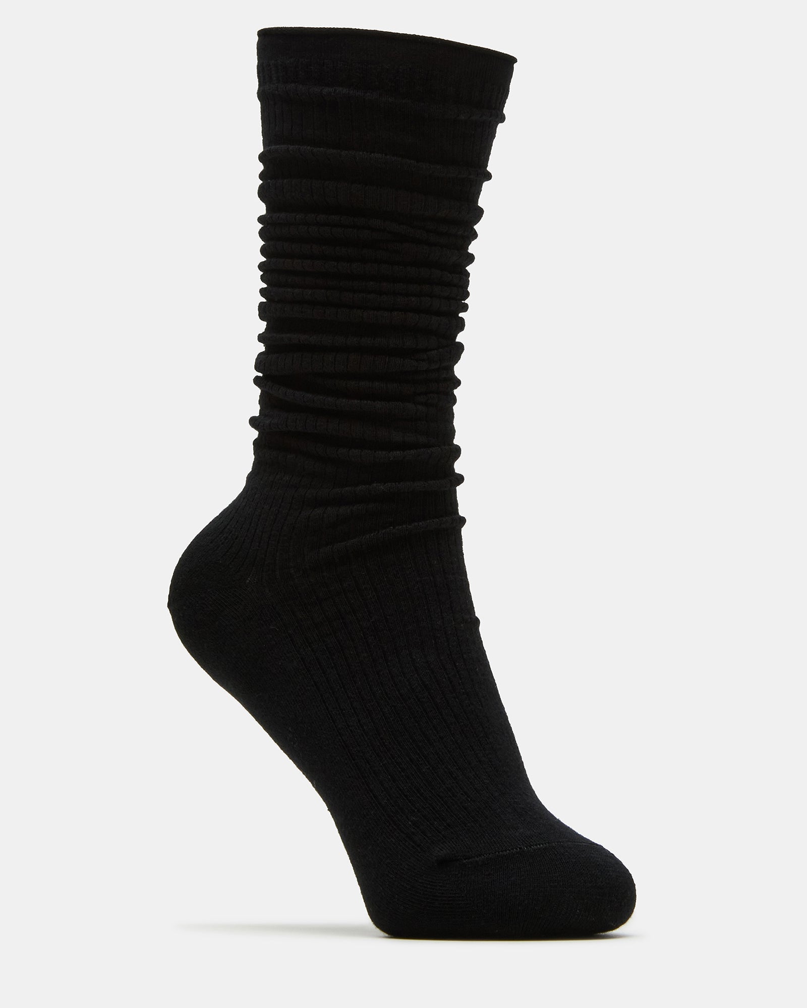 Model wearing slouchy crew socks casually rolled during a city walk