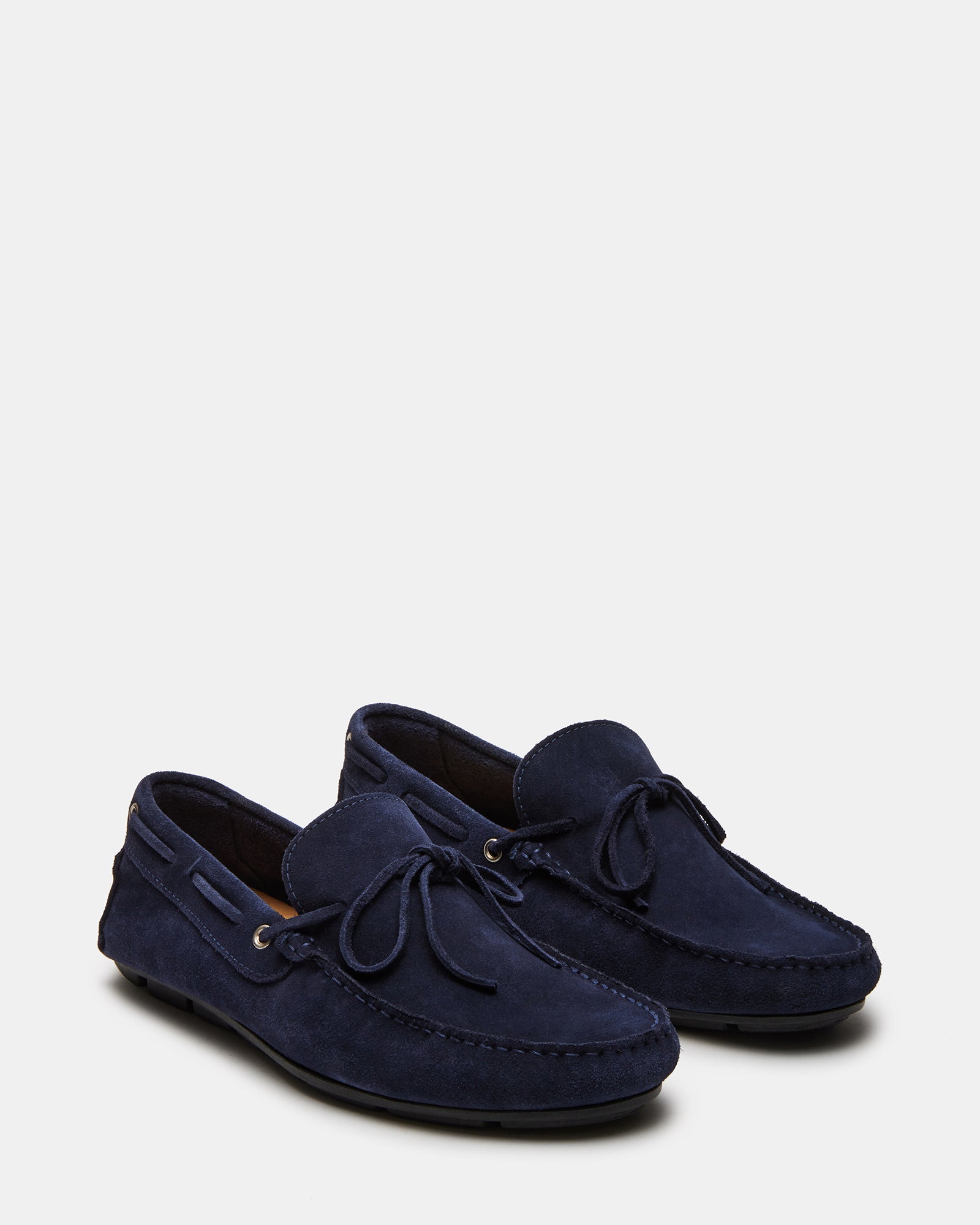 Lifestyle shot of suede penny loafers worn with chinos on downtown LA sidewalks.