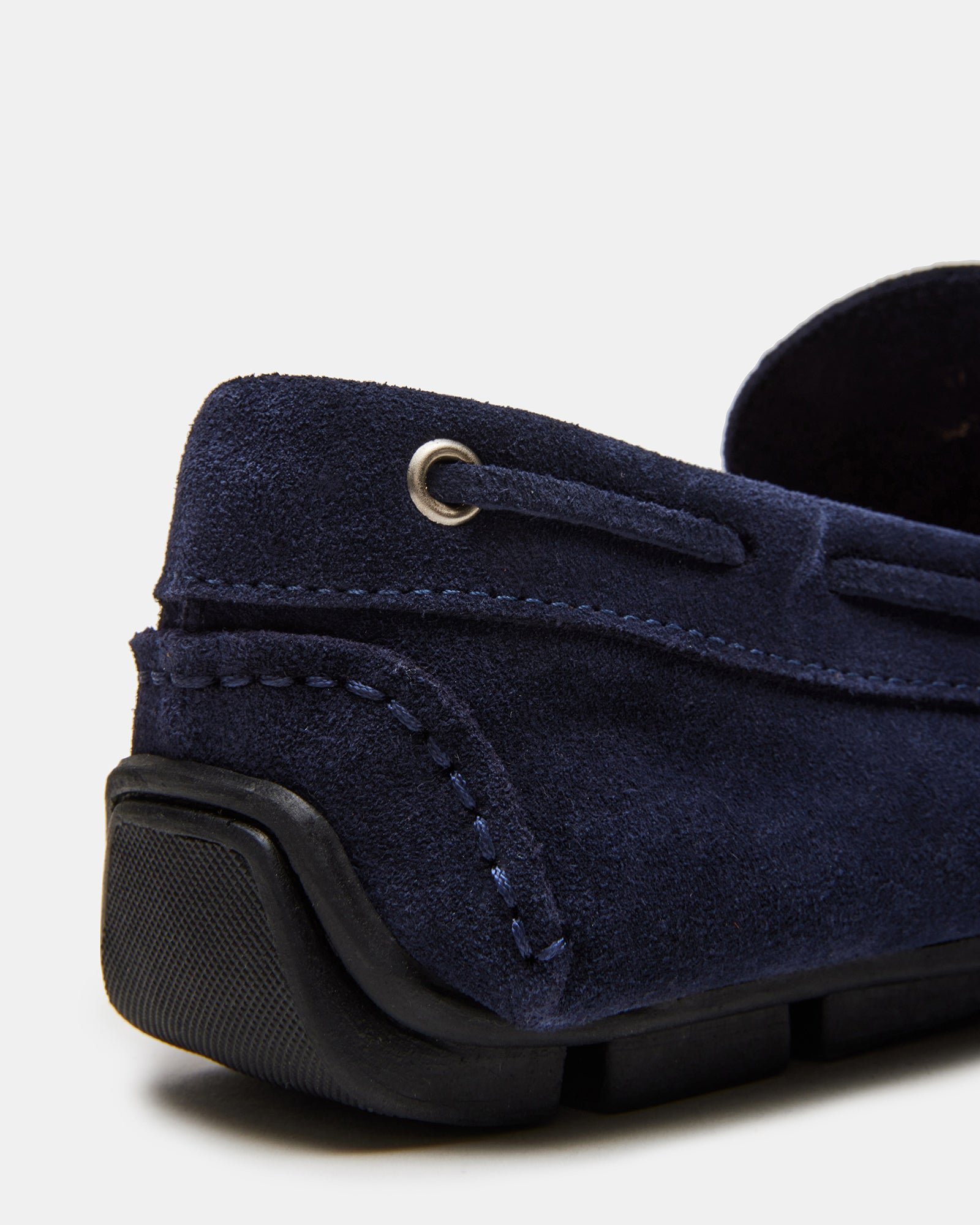 Top-down view of mens slip-on shoes resting on a wood bench in natural light.