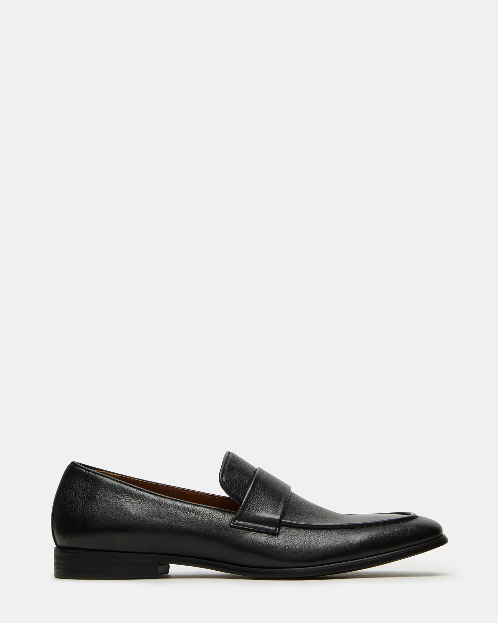 Black leather loafers on a hardwood floor, styled for business attire