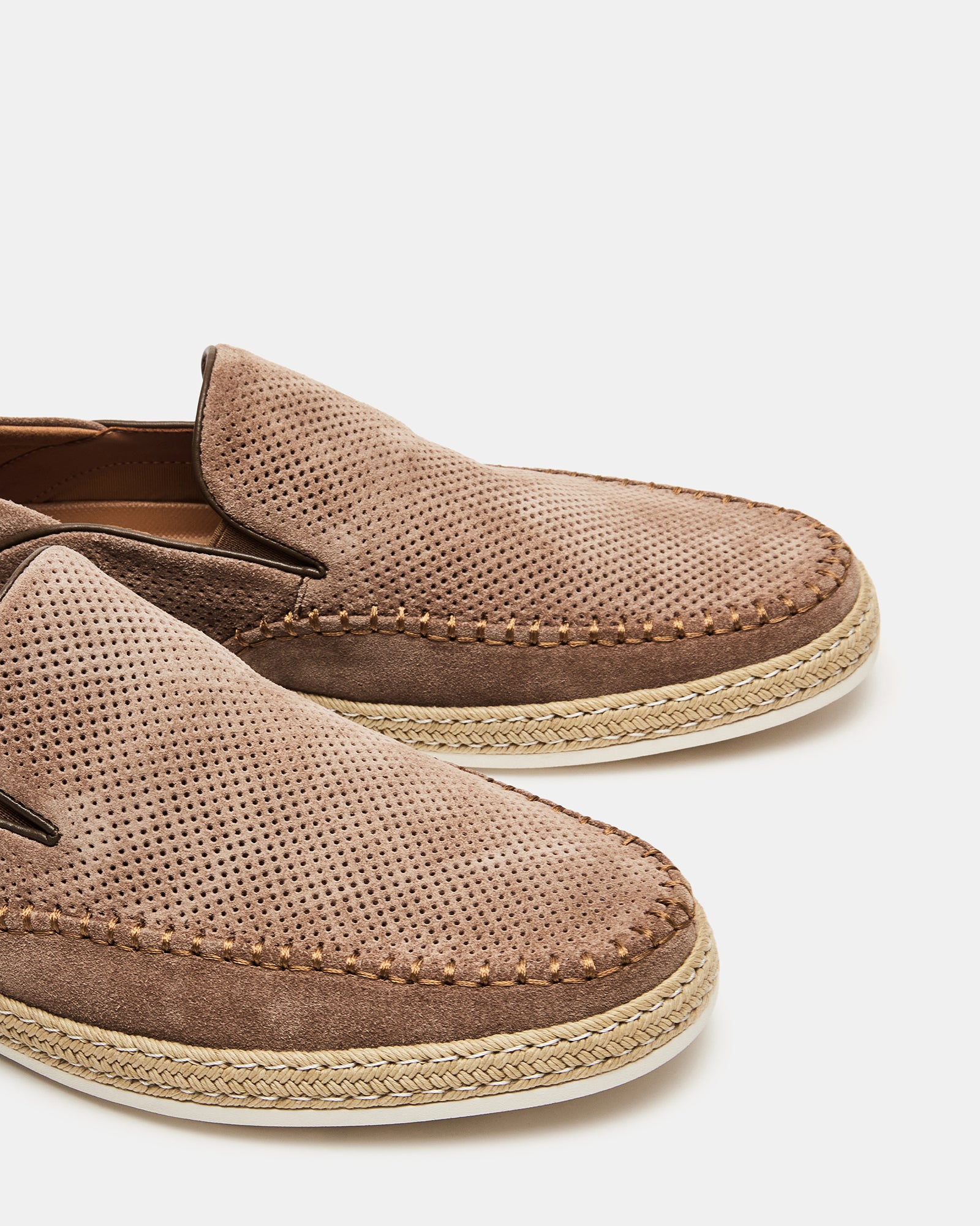 Tobacco suede loafers on a wooden floor, showcasing rubber sole