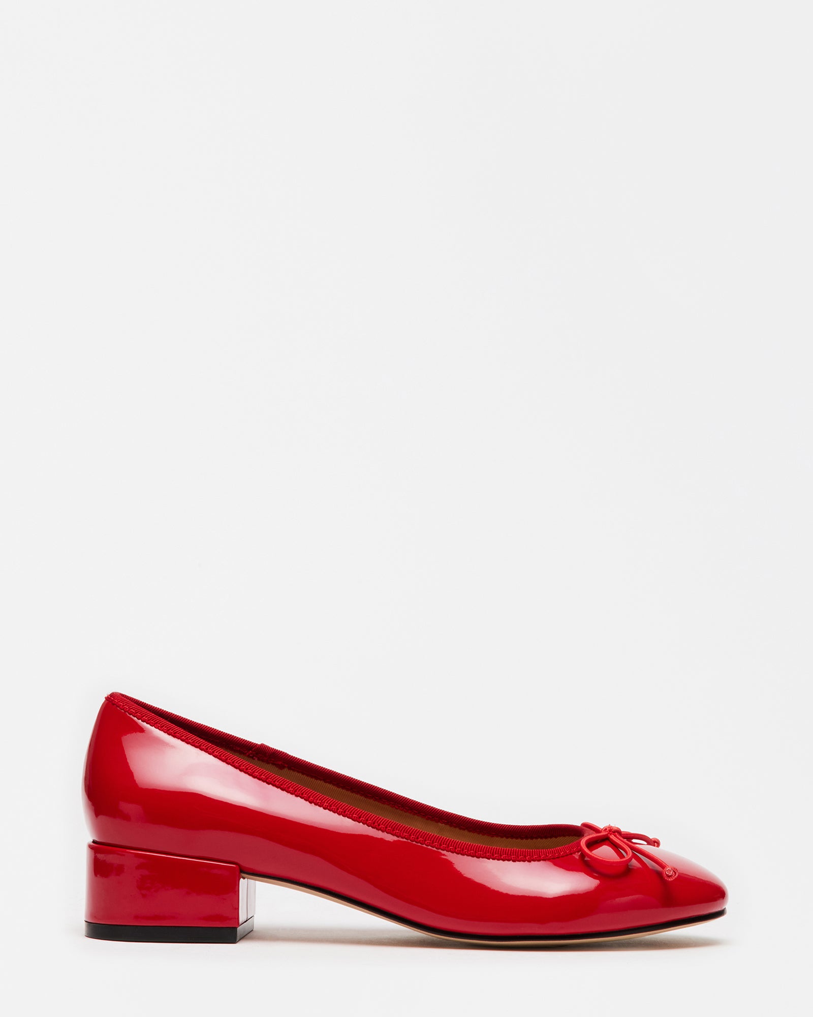 Close-up of red slip-on pumps with cord bow and block heel for wedding use