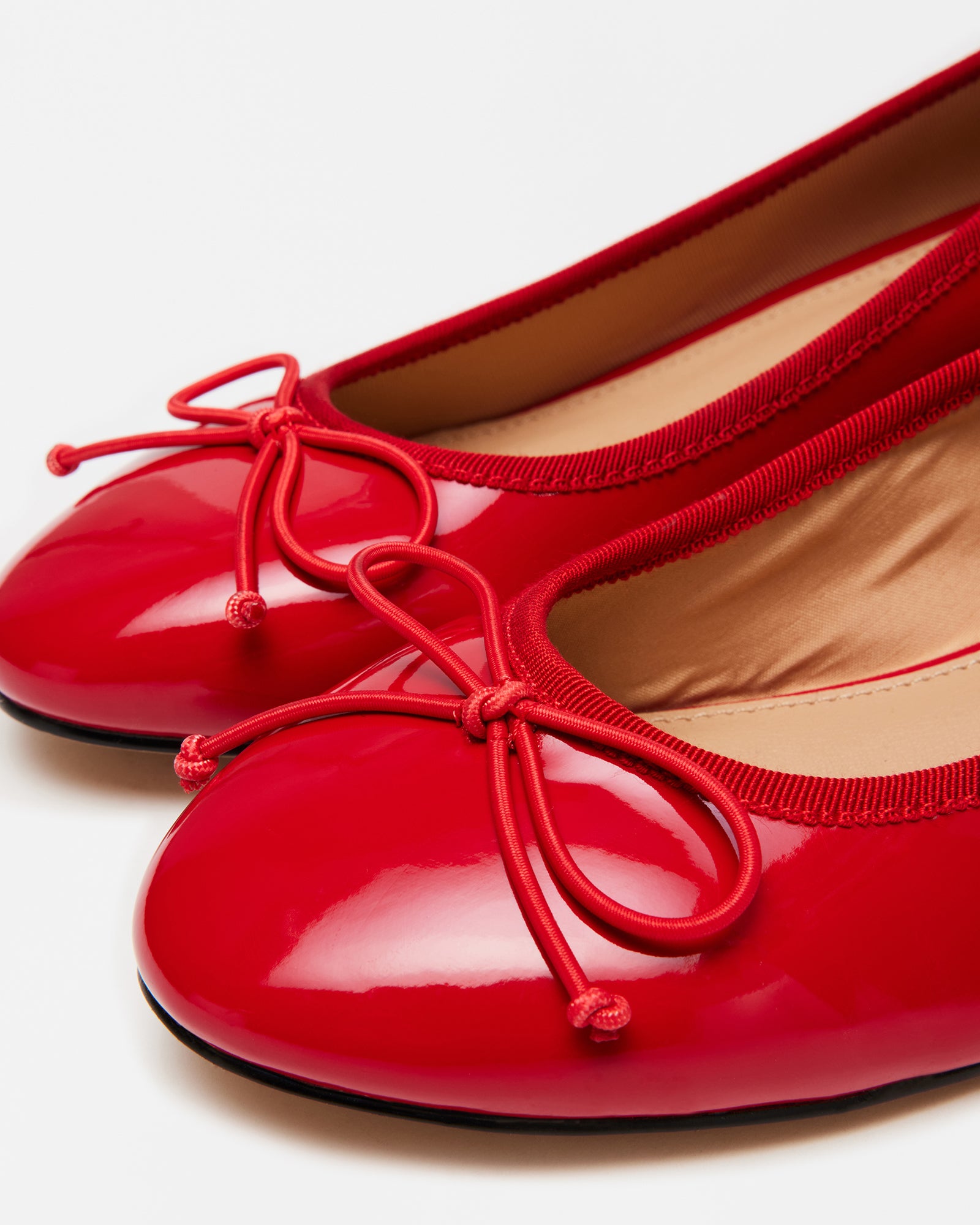 Close-up of red slip-on pumps with cord bow and block heel for wedding use