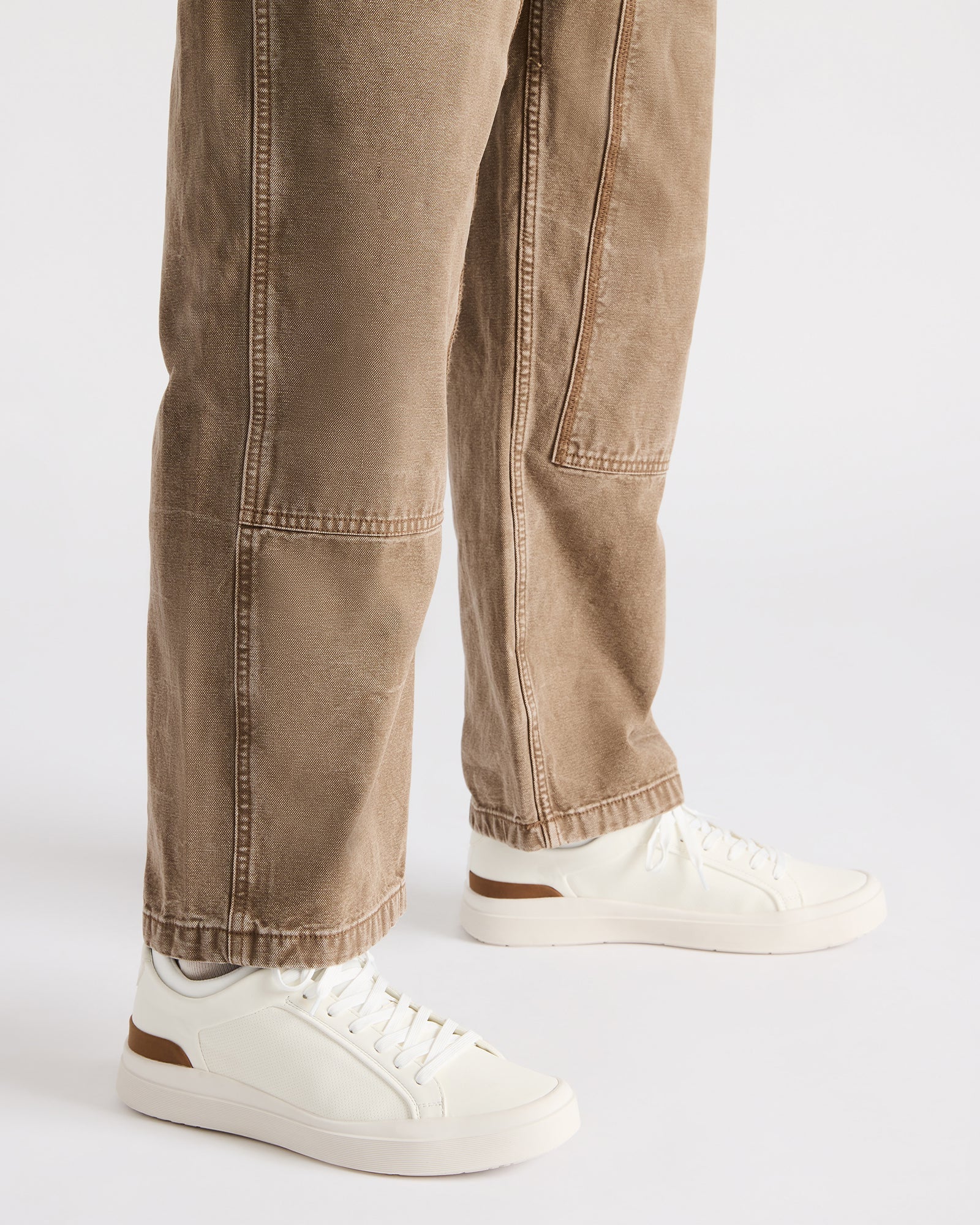 Pair of white sneakers styled with neutral-toned outfit