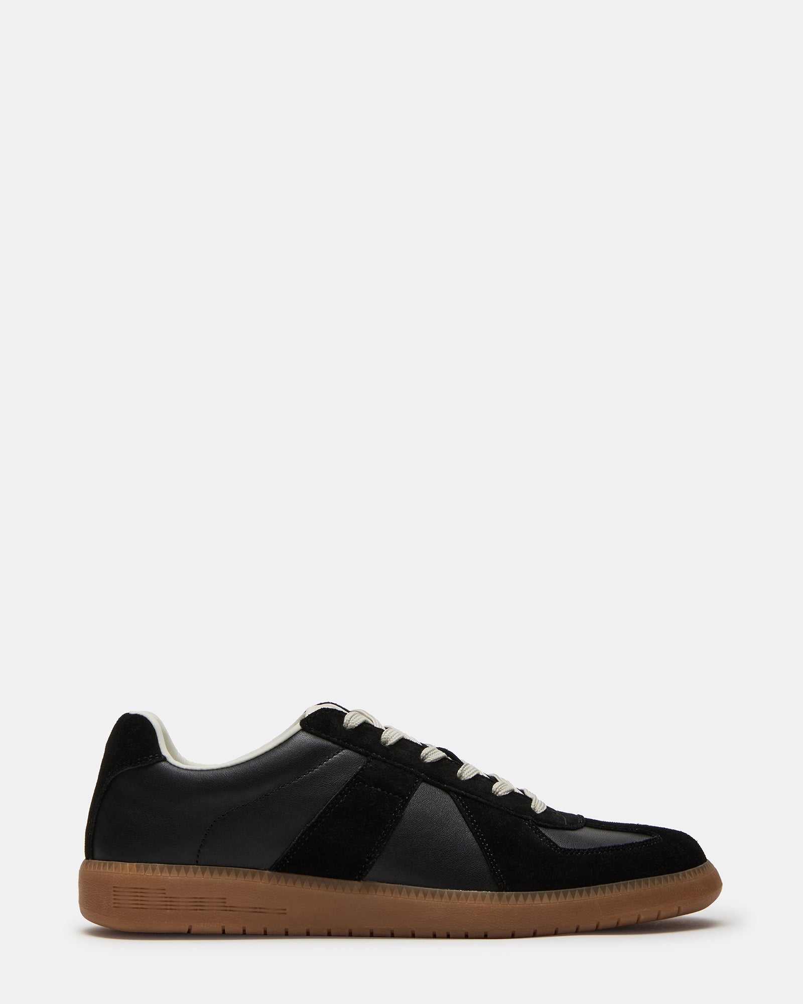 Black leather low-top sneakers with lace-up closure on a casual outfit
