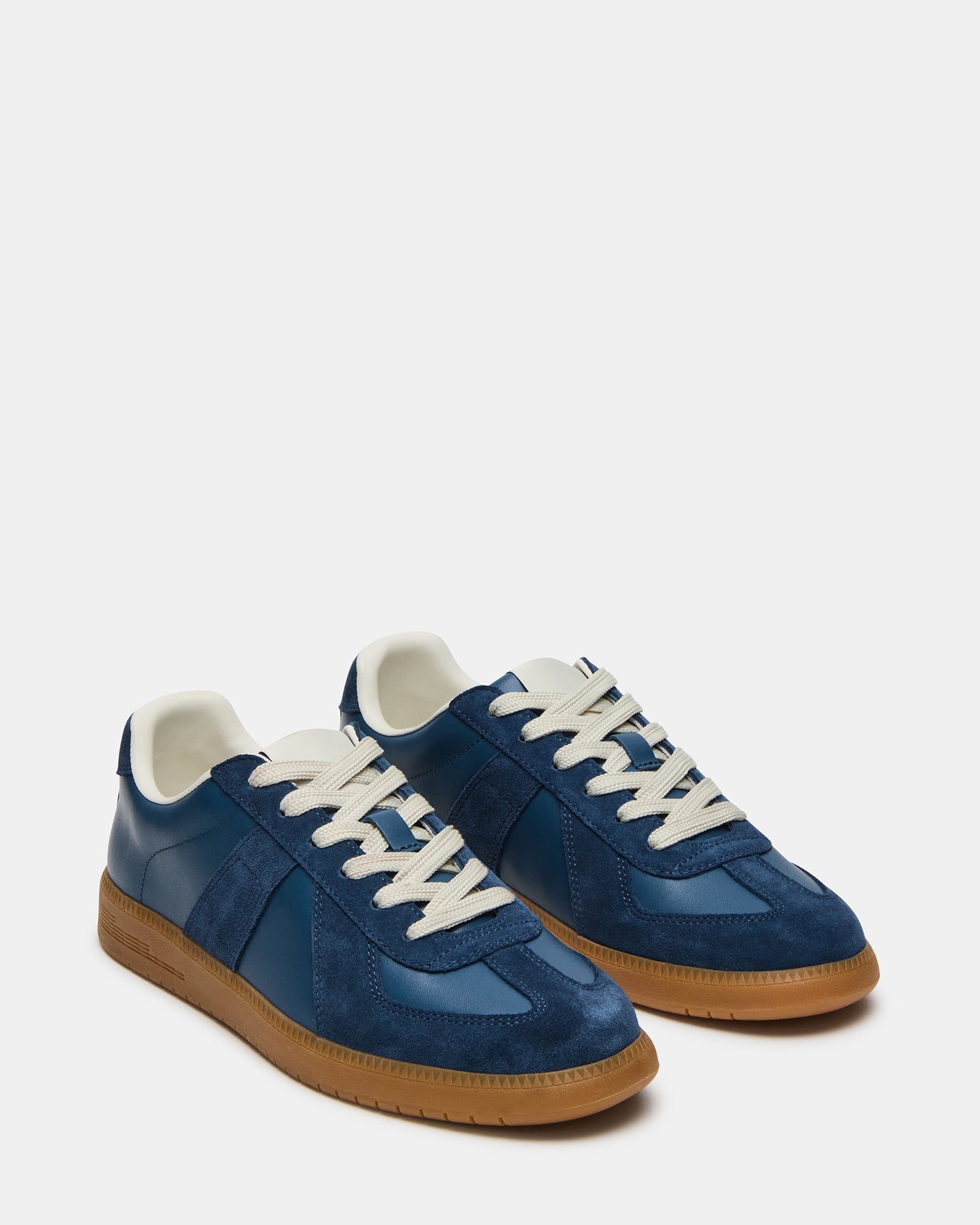 DIXON navy suede low-top sneakers worn casually on a city street, illustrating their versatile style.