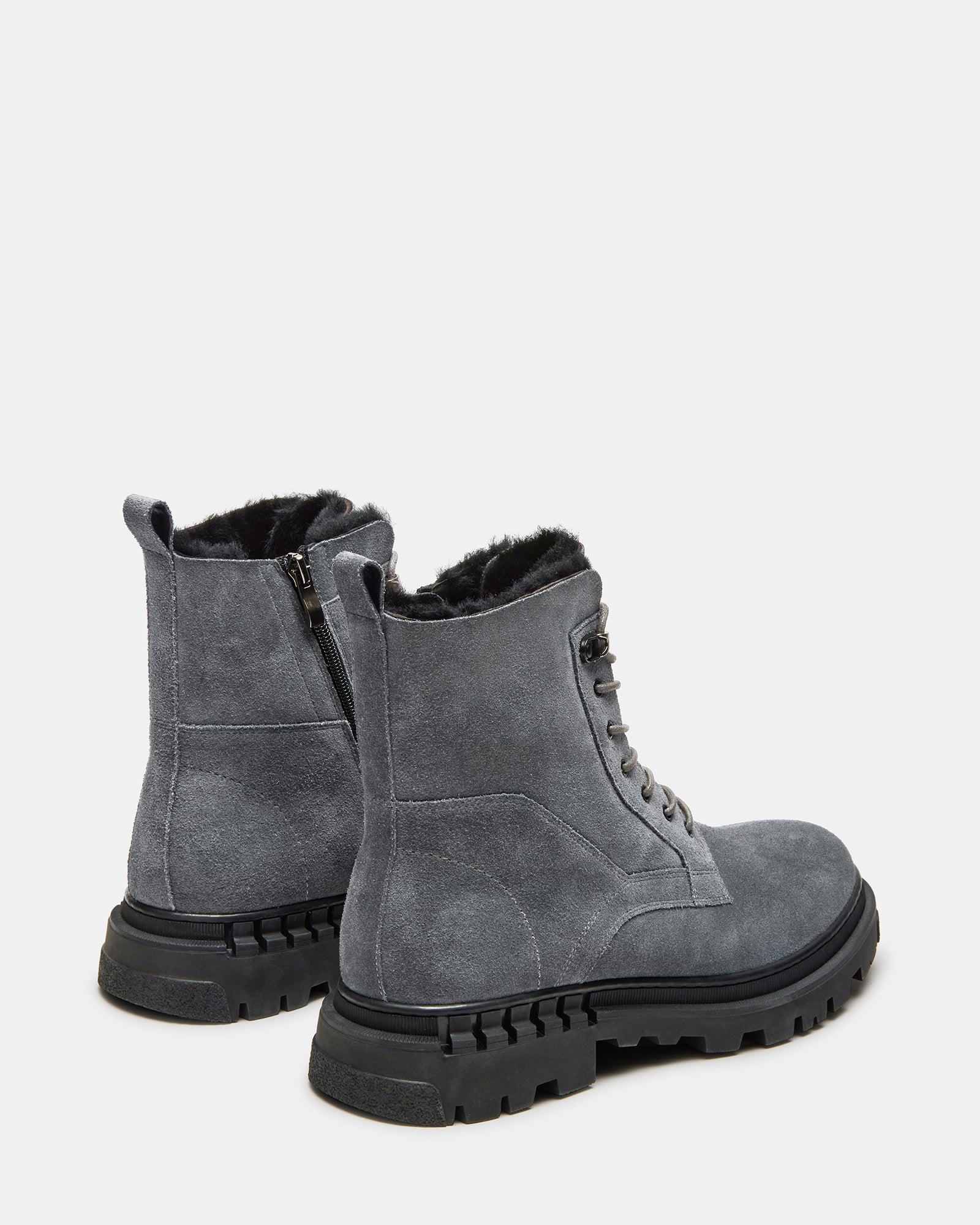Close-up of brown suede boots showing faux fur lining and pull tab