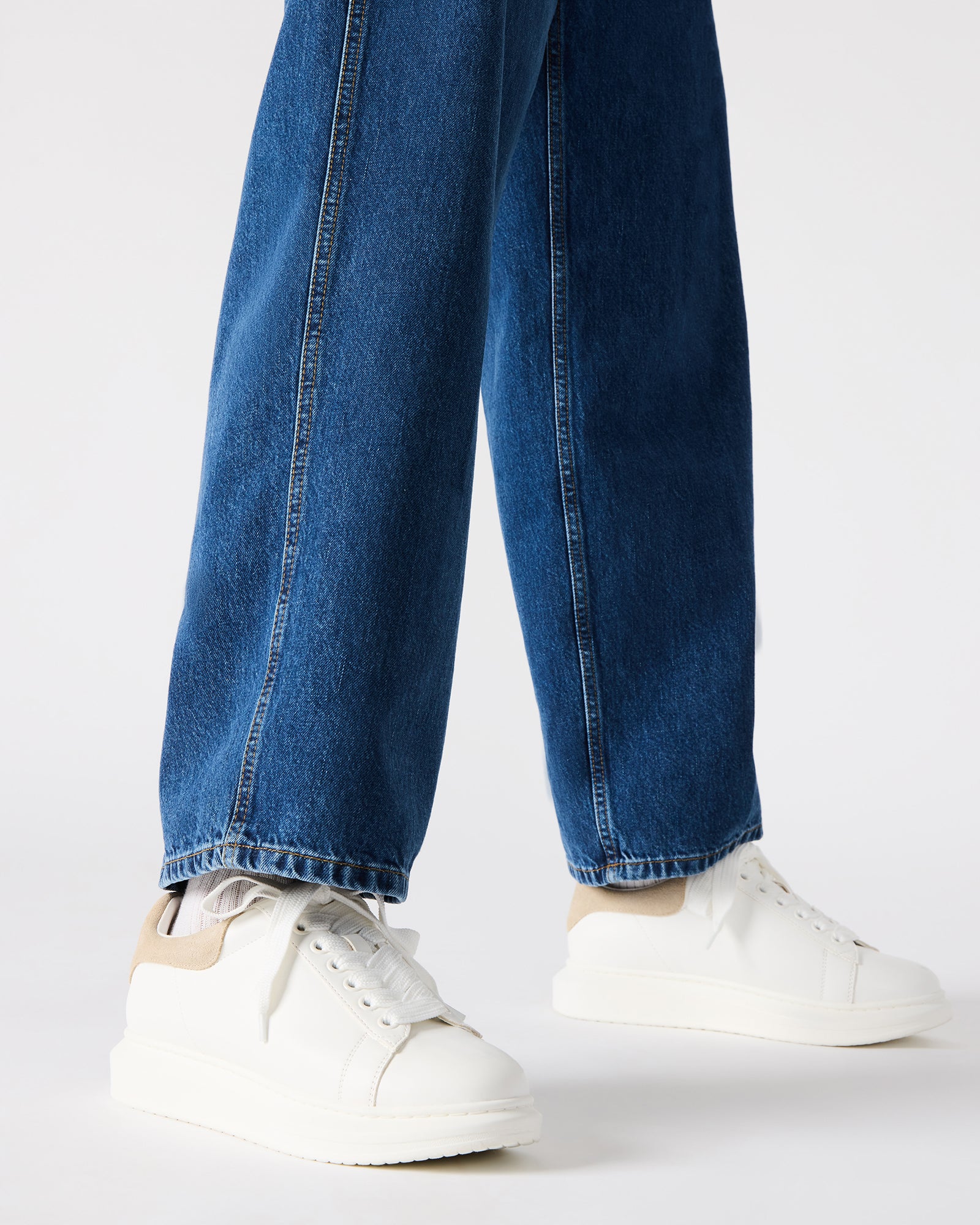 Side profile of white platform sneakers showcasing the 1.5-inch heel.