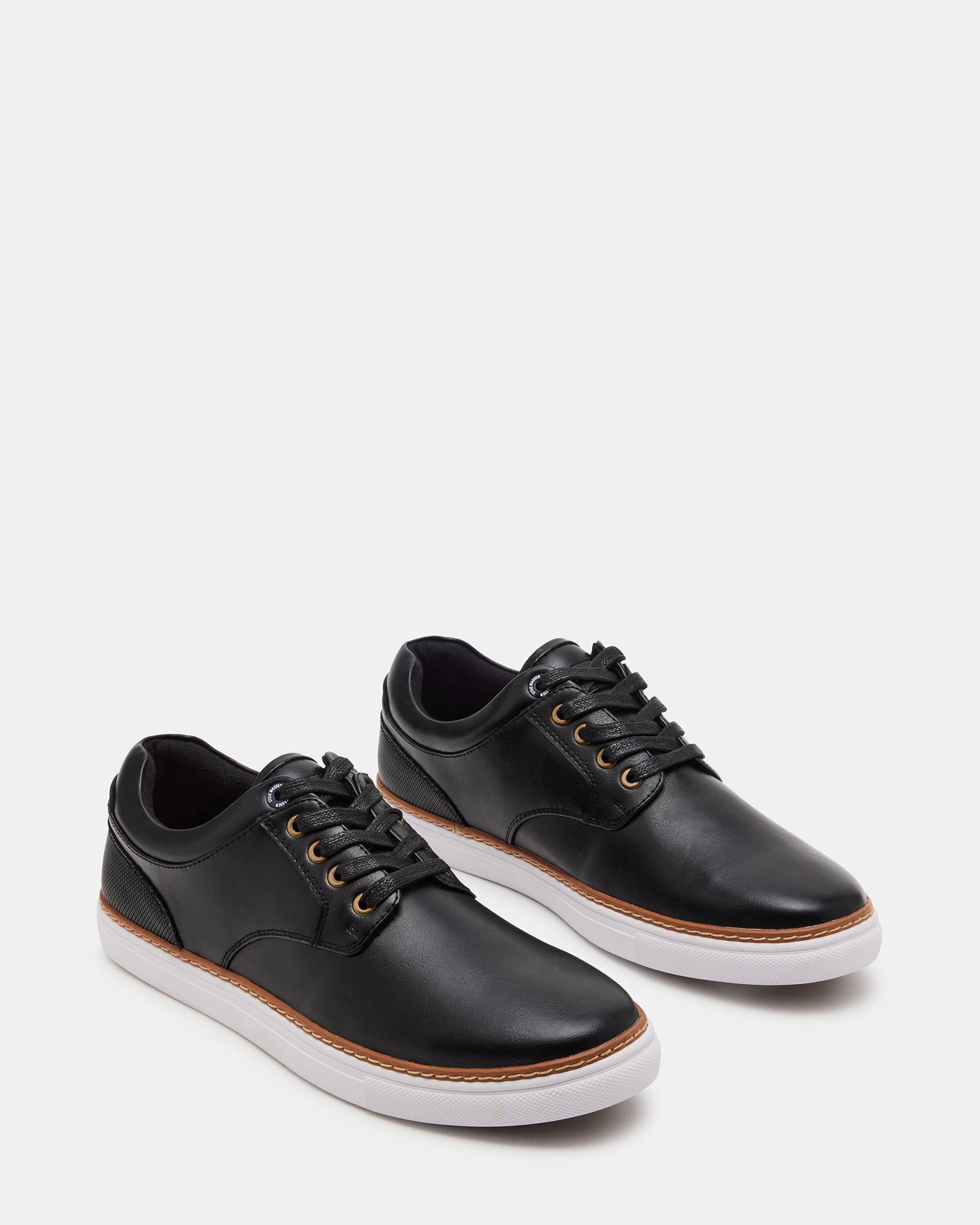 Side view of GUSS BLACK sneakers paired with business casual attire