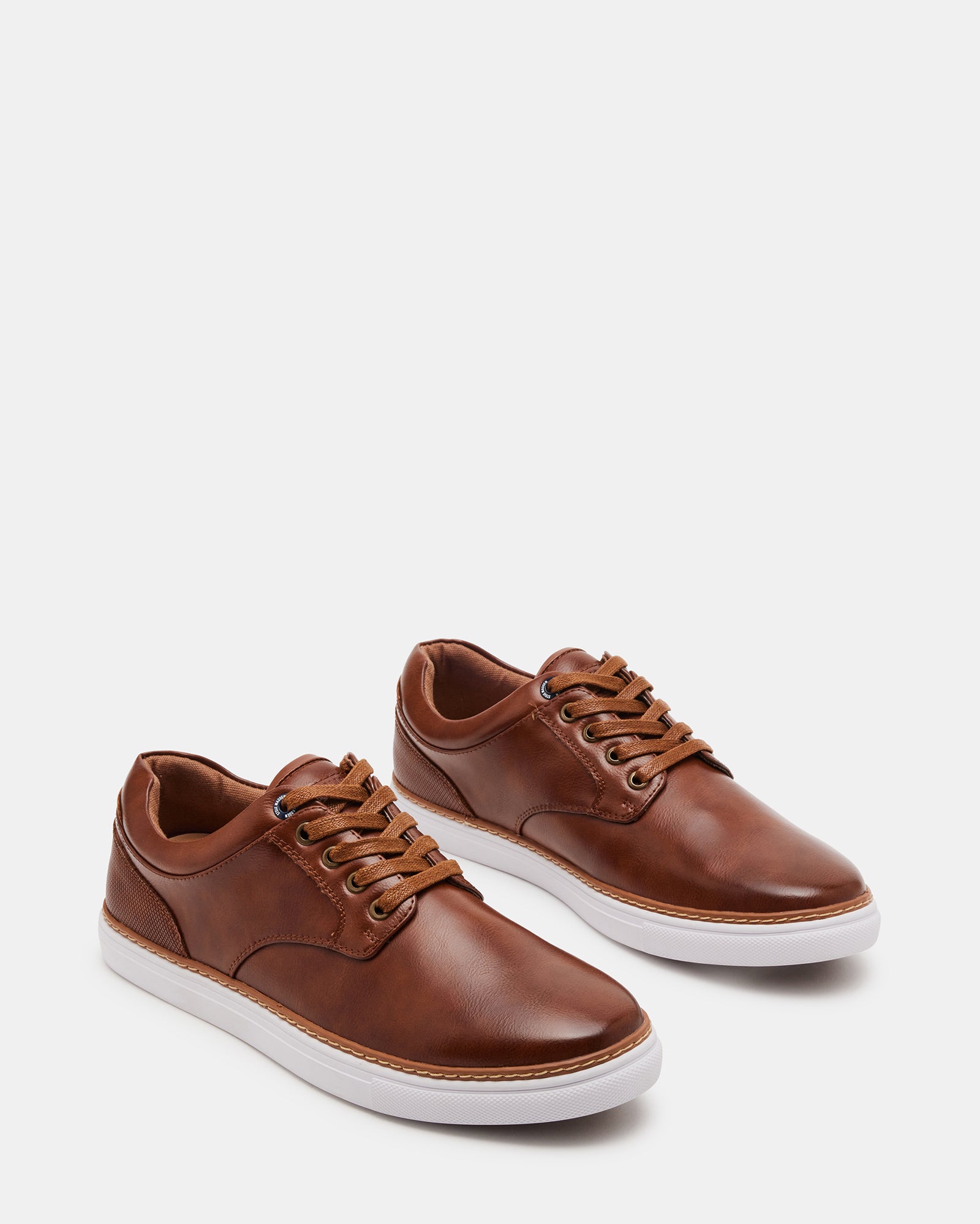 GUSS lace-up sneakers worn during a casual outdoor event.