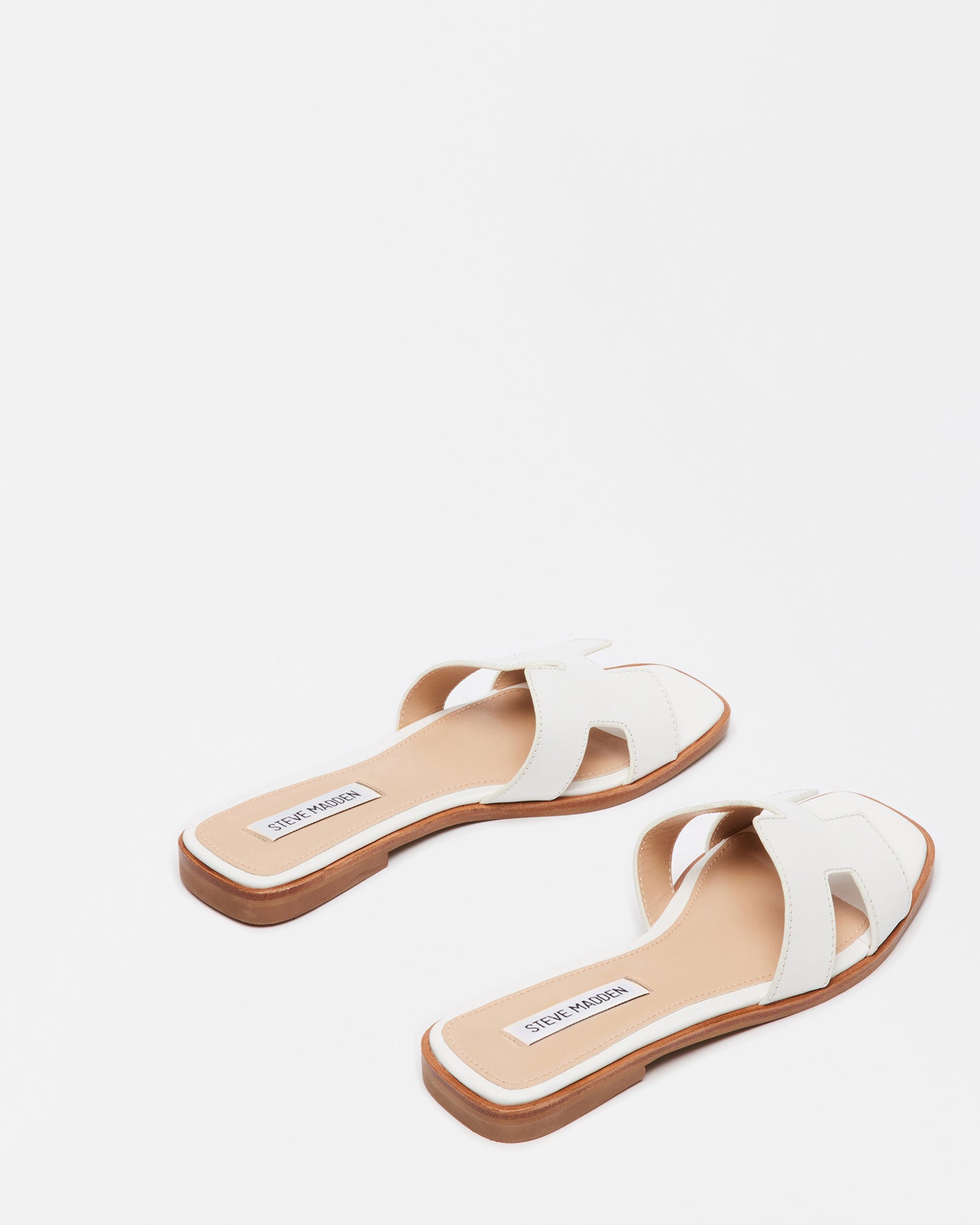 Hayden white leather sandals paired with summer attire in a sunny setting.