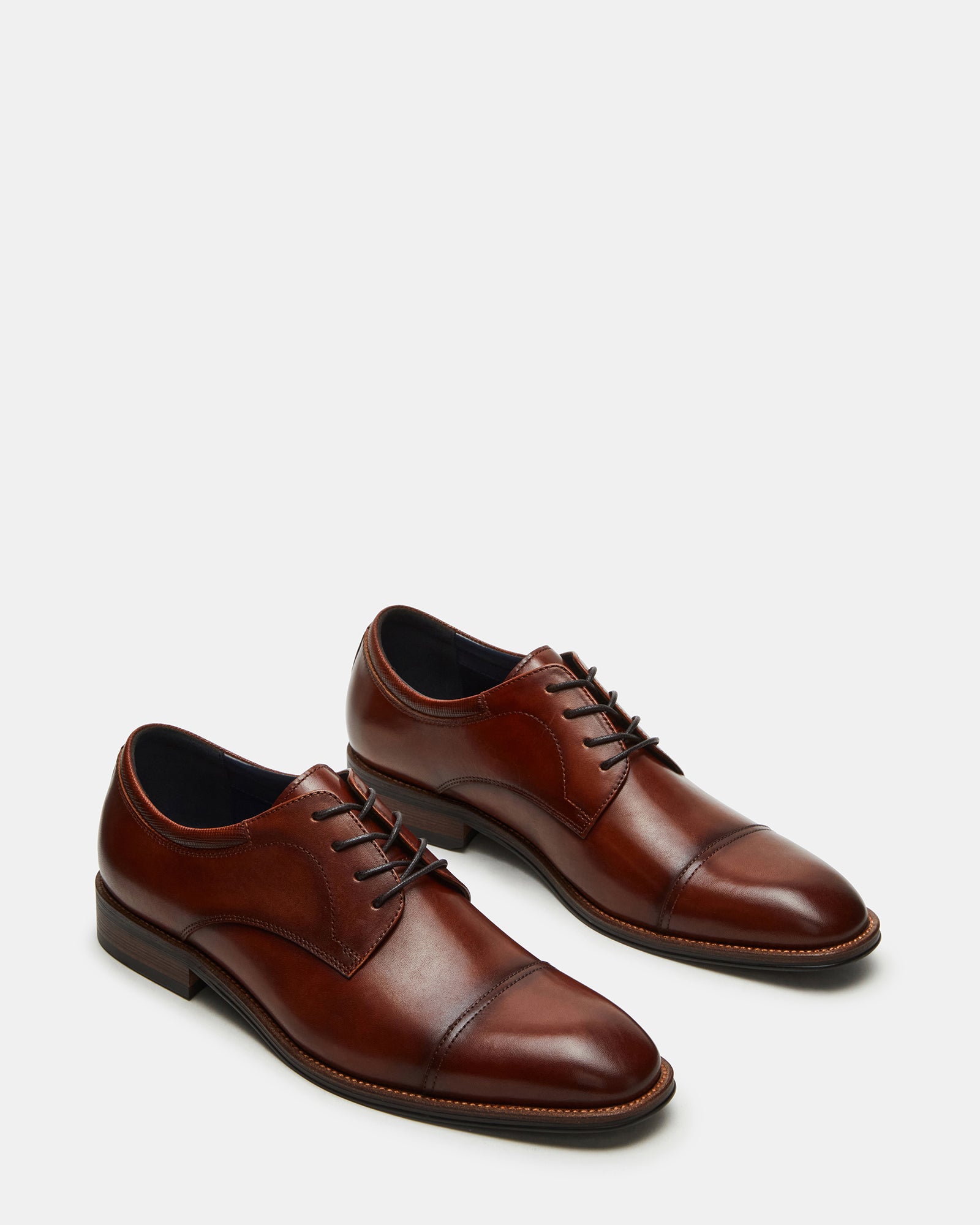 Close-up of the tan leather upper and rubber sole of the dress shoes.